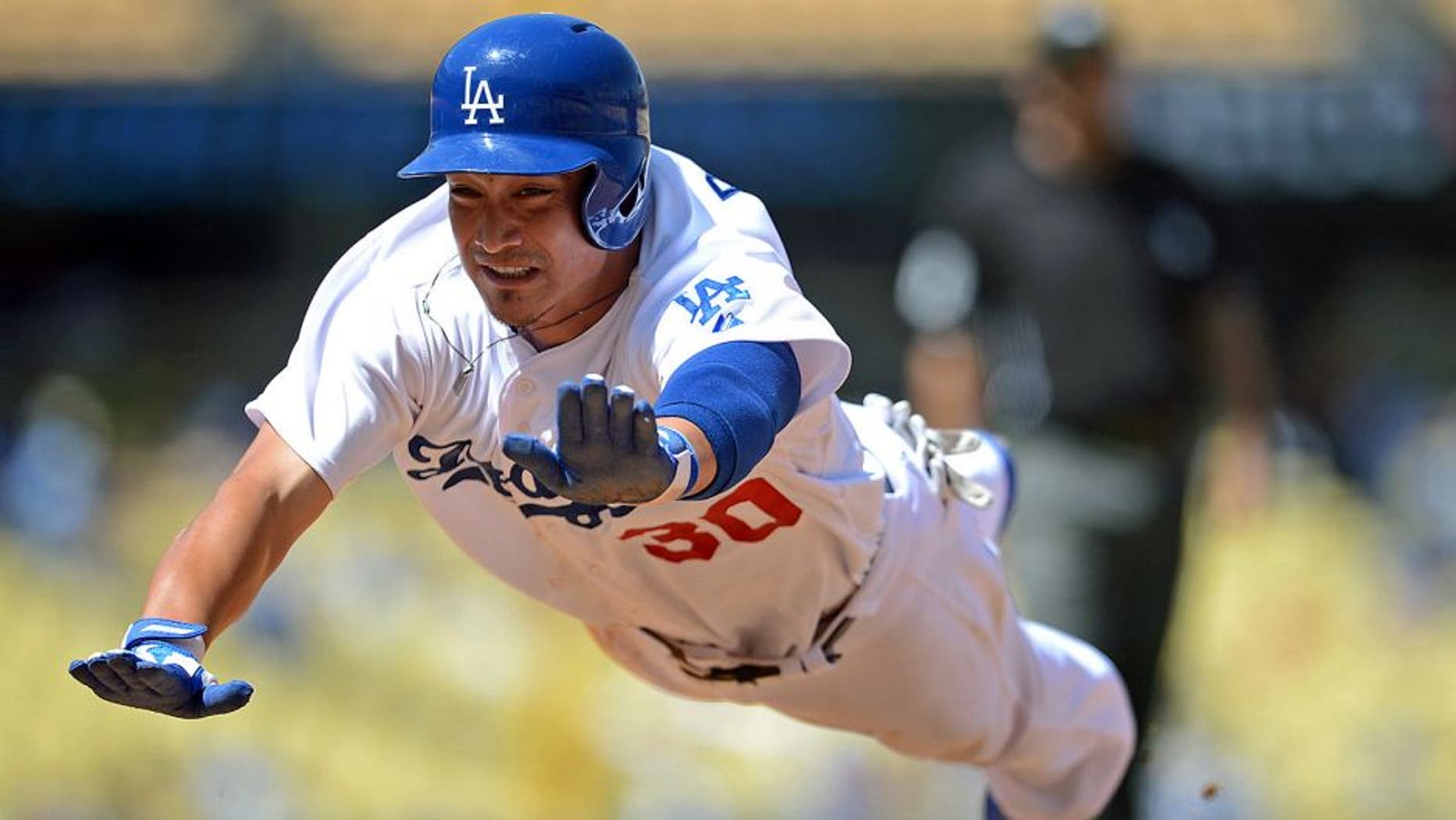 Sep 3, 2014; Los Angeles, CA, USA; Los Angeles Dodgers second baseman Darwin Barney (30) dives back to first base to avoid a double play in the sixth inning of the game against the Washington Nationals at Dodger Stadium. Nationals won 8-5 in fourteen innings. Mandatory Credit: Jayne Kamin-Oncea-USA TODAY Sports