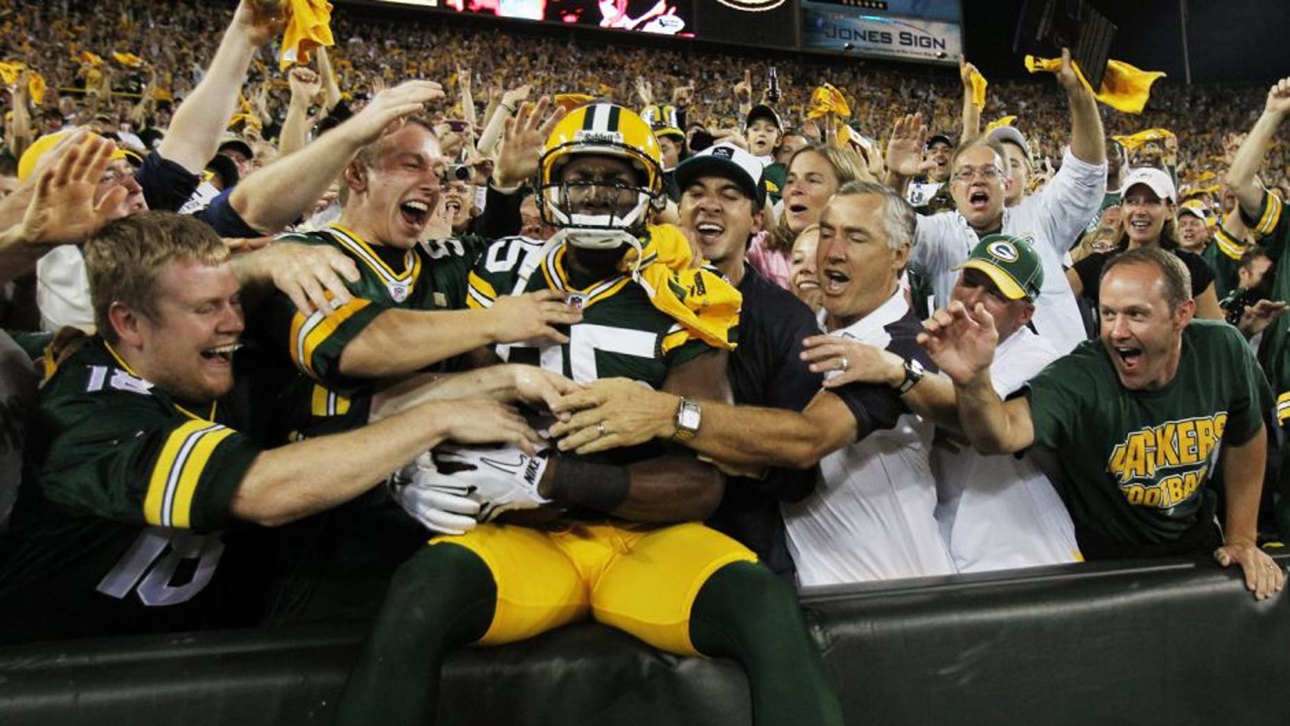 GREEN BAY, WI - SEPTEMBER 08: Greg Jennings #85 of the Green Bay Packers is mobbed by fans after leaping into the stands following a touchdown catch against the New Orleans Saints during the NFL opening season game at Lambeau Field on September 8, 2011 in Green Bay, Wisconsin. The Packers defeated the Saints 42-34. (Photo by Jonathan Daniel/Getty Images)