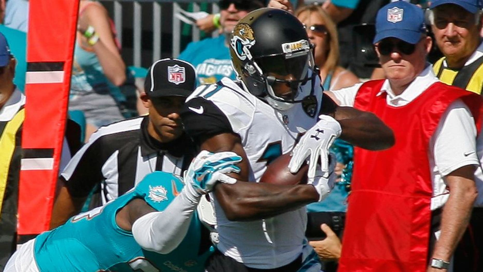 Sep 20, 2015; Jacksonville, FL, USA; Jacksonville Jaguars wide receiver Marqise Lee (11) tries to get by Miami Dolphins cornerback Brice McCain (24) on his first NFL catch in the first quarter at EverBank Field. Mandatory Credit: Phil Sears-USA TODAY Sports