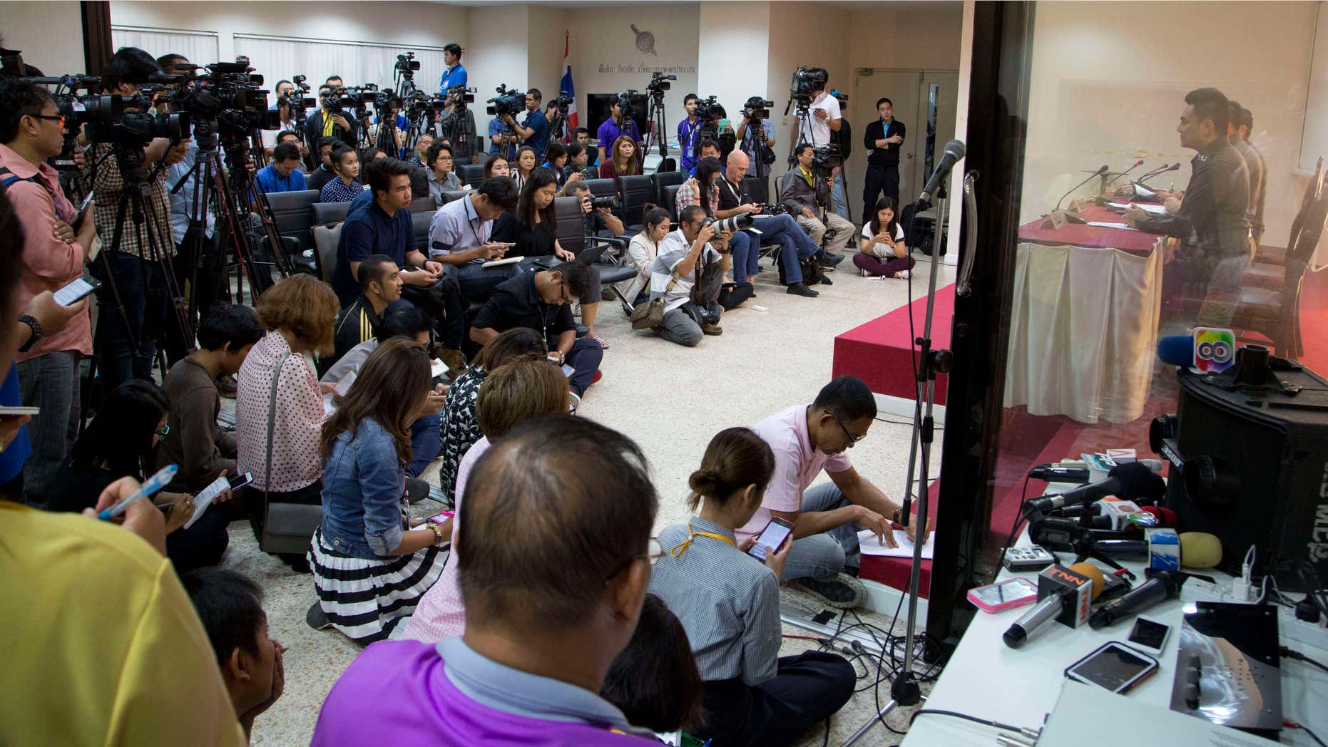 Dec. 4, 2015: Media listen as National police deputy spokesman Col. Songpol Wattanachai addresses a press conference in Bangkok, Thailand.