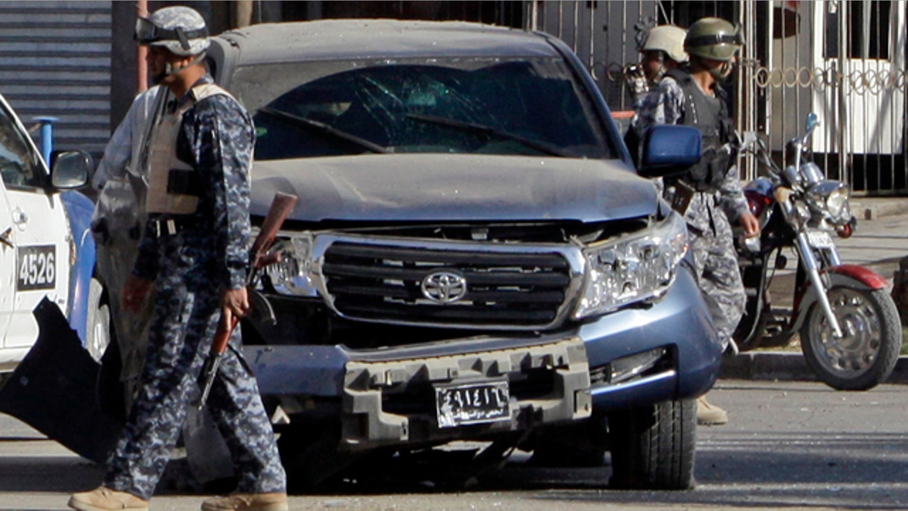 Dec. 4: Iraqi security forces stand guard at the scene of a roadside bomb attack which targeted a government convoy in Baghdad, Iraq.