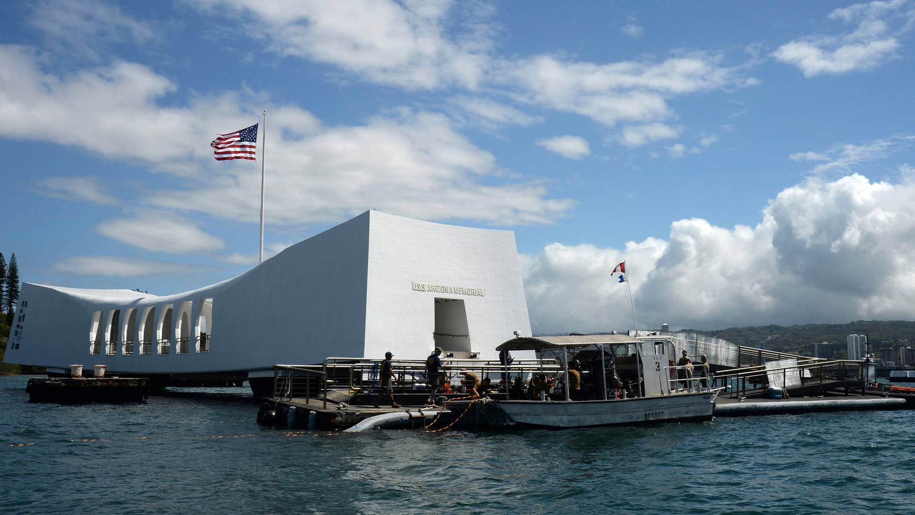 FILE- In this June 3, 2015 file photo released by the U.S. Navy, sailors work to repair the floating dock next to the USS Arizona Memorial in Pearl Harbor, Hawaii, after the USNS Mercy hospital ship struck the memorial's dock in May as it was leaving Pearl Harbor.