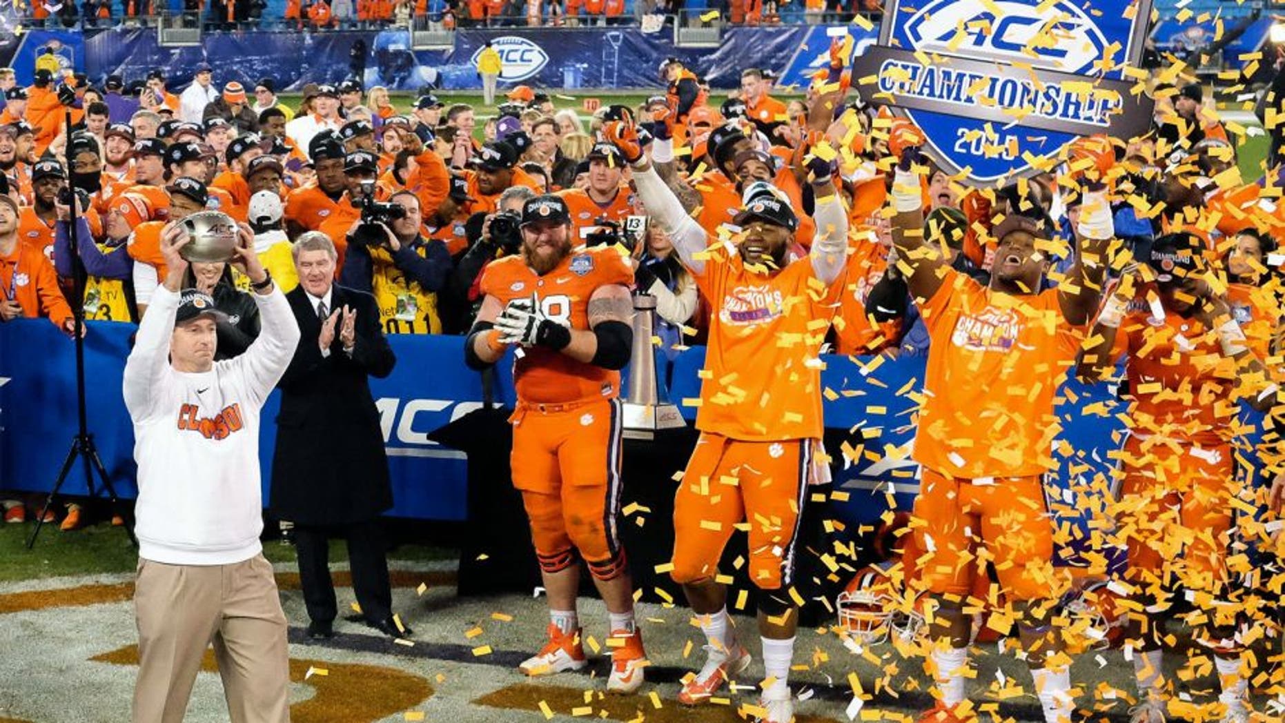 Dec 5, 2015; Charlotte, NC, USA; Clemson Tigers head coach Dabo Swinney (L) holds up the trophy for fans after winning the ACC football championship game at Bank of America Stadium. The Tigers won 45-37. Mandatory Credit: Jim Dedmon-USA TODAY Sports