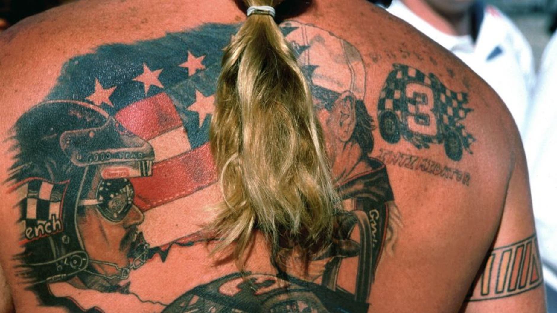 DAYTONA BEACH, FL - FEBRUARY 17, 2002: A NASCAR and Dale Earnhardt Sr. fan shows off his tatoos at the Daytona International Speedway prior to the start of the 2002 Daytona 500 on February 17, 2002 in Daytona Beach, Florida. (Photo by Robert Alexander/Archive Photos/Getty Images)