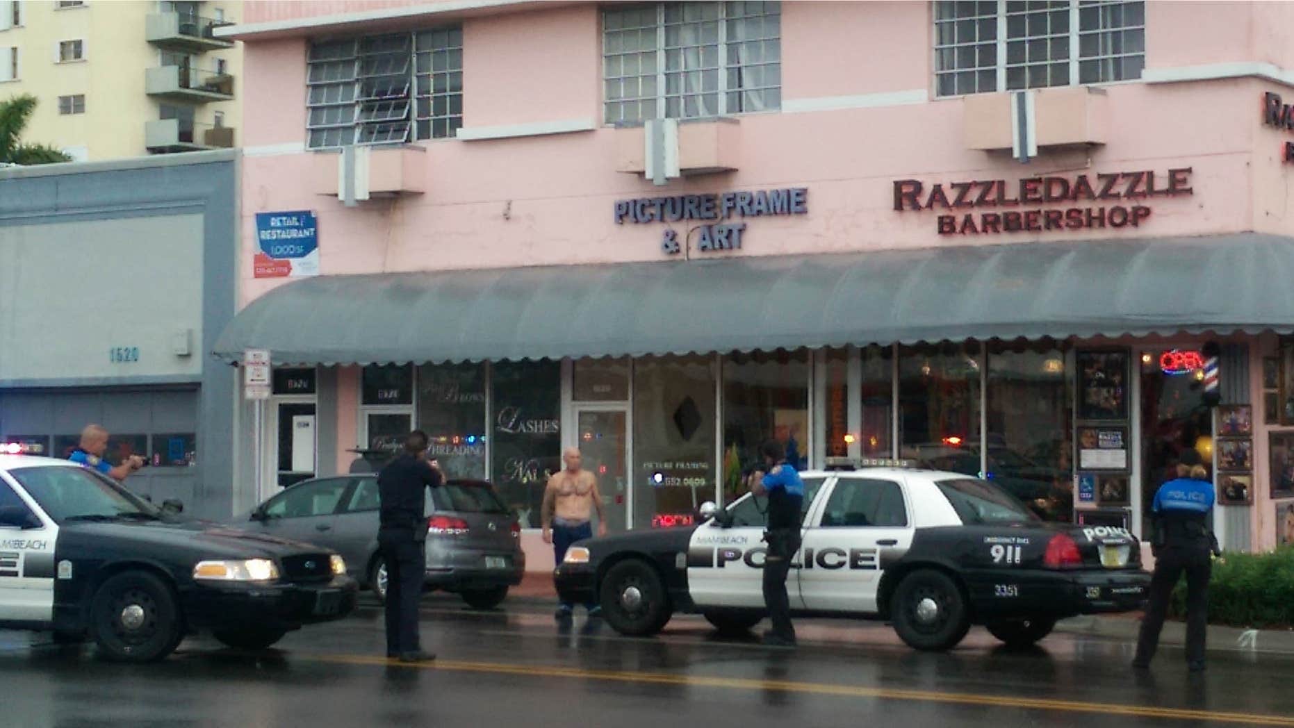 Dec. 5, 2015: In this photo provided by Marcellus Johnson, authorities draw their guns on a man suspected in a bank robbery in Miami Beach, Fla.
