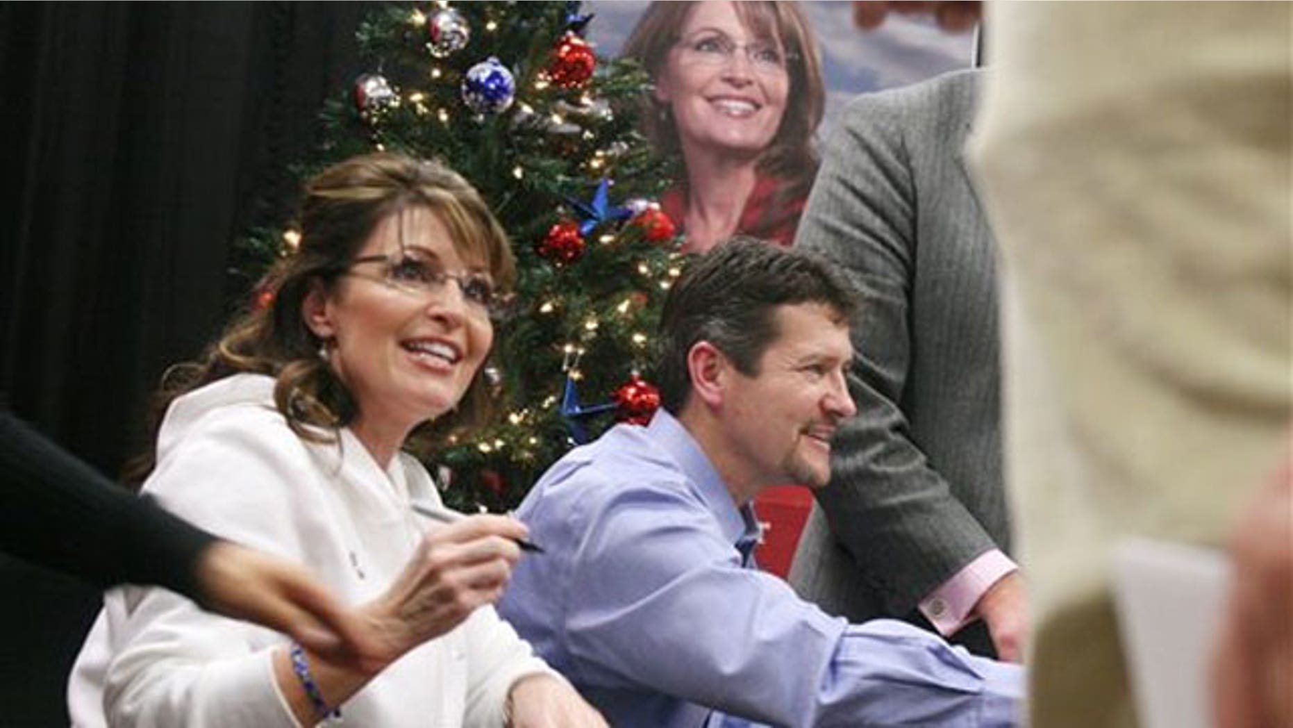 Dec. 4: Sarah Palin, left, signs her book 'Going Rogue' with help from her husband, Todd, in Fort Hood, Texas (AP).
