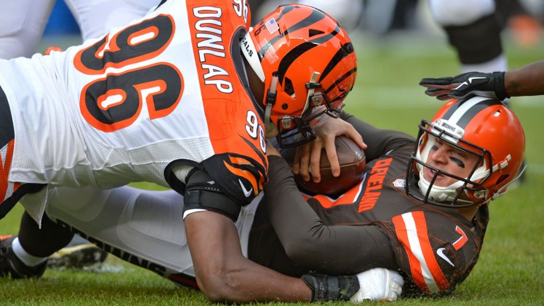 Cleveland Browns quarterback Austin Davis (7) is tackled by Cincinnati Bengals defensive end Carlos Dunlap (96) in the first half of an NFL football game, Sunday, Dec. 6, 2015, in Cleveland. (AP Photo/David Richard)