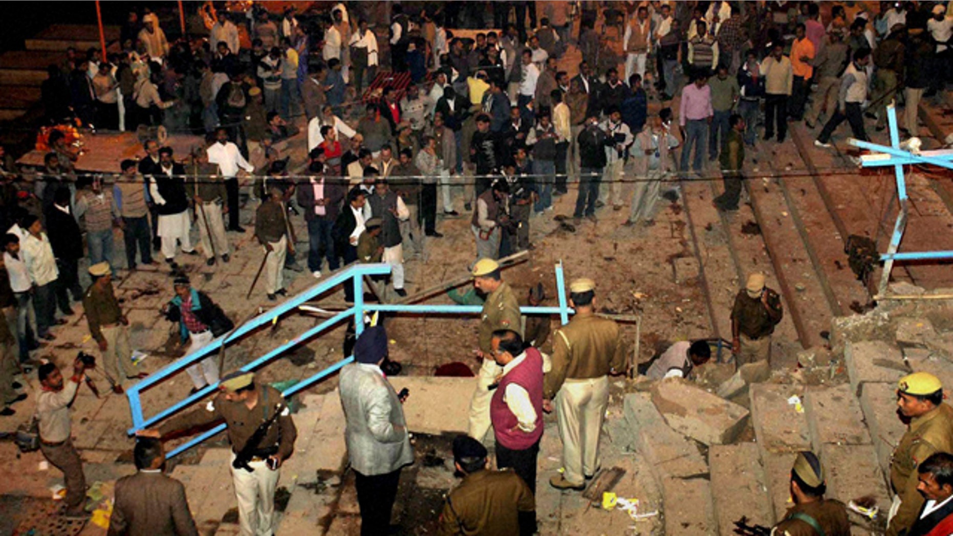 Dec. 7: People watch as policemen and officials inspect the site of an explosion in Varanasi, India.