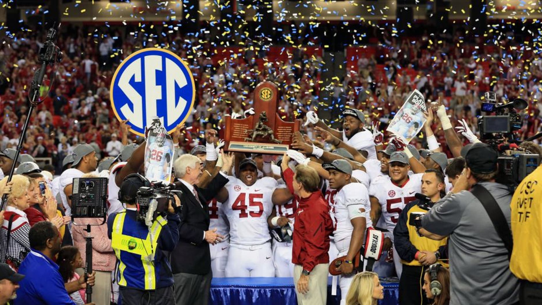 Dec 6, 2014; Atlanta, GA, USA; Alabama Crimson Tide head coach Nick Saban and his team celebrate with the trophy after the 2014 SEC Championship Game against the Missouri Tigers at the Georgia Dome. Alabama defeated Missouri 42-13. Mandatory Credit: Kevin Liles-USA TODAY Sports