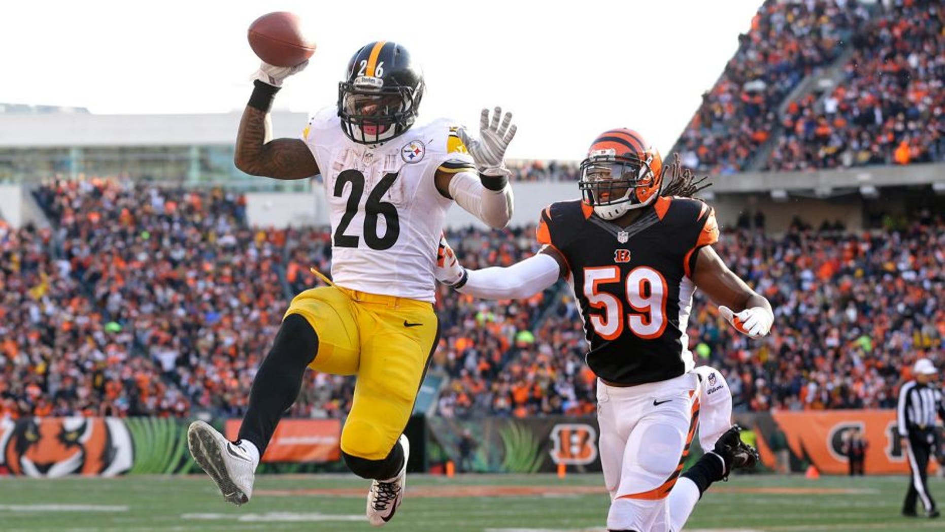 Pittsburgh Steelers running back Le'Veon Bell (26) scores on a 10-yard touchdown reception against Cincinnati Bengals outside linebacker Emmanuel Lamur (59) during the second half of an NFL football game Sunday, Dec. 7, 2014 in Cincinnati. (AP Photo/Michael Conroy)