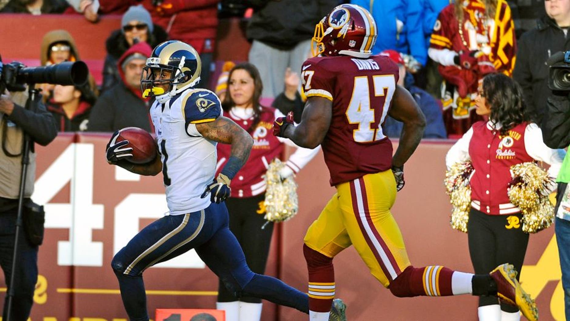 Dec 7, 2014; Landover, MD, USA; St. Louis Rams wide receiver Tavon Austin (11) returns a punt for a touchdown as Washington Redskins defensive back Akeem Davis (47) chases during the second half at FedEx Field. Mandatory Credit: Brad Mills-USA TODAY Sports