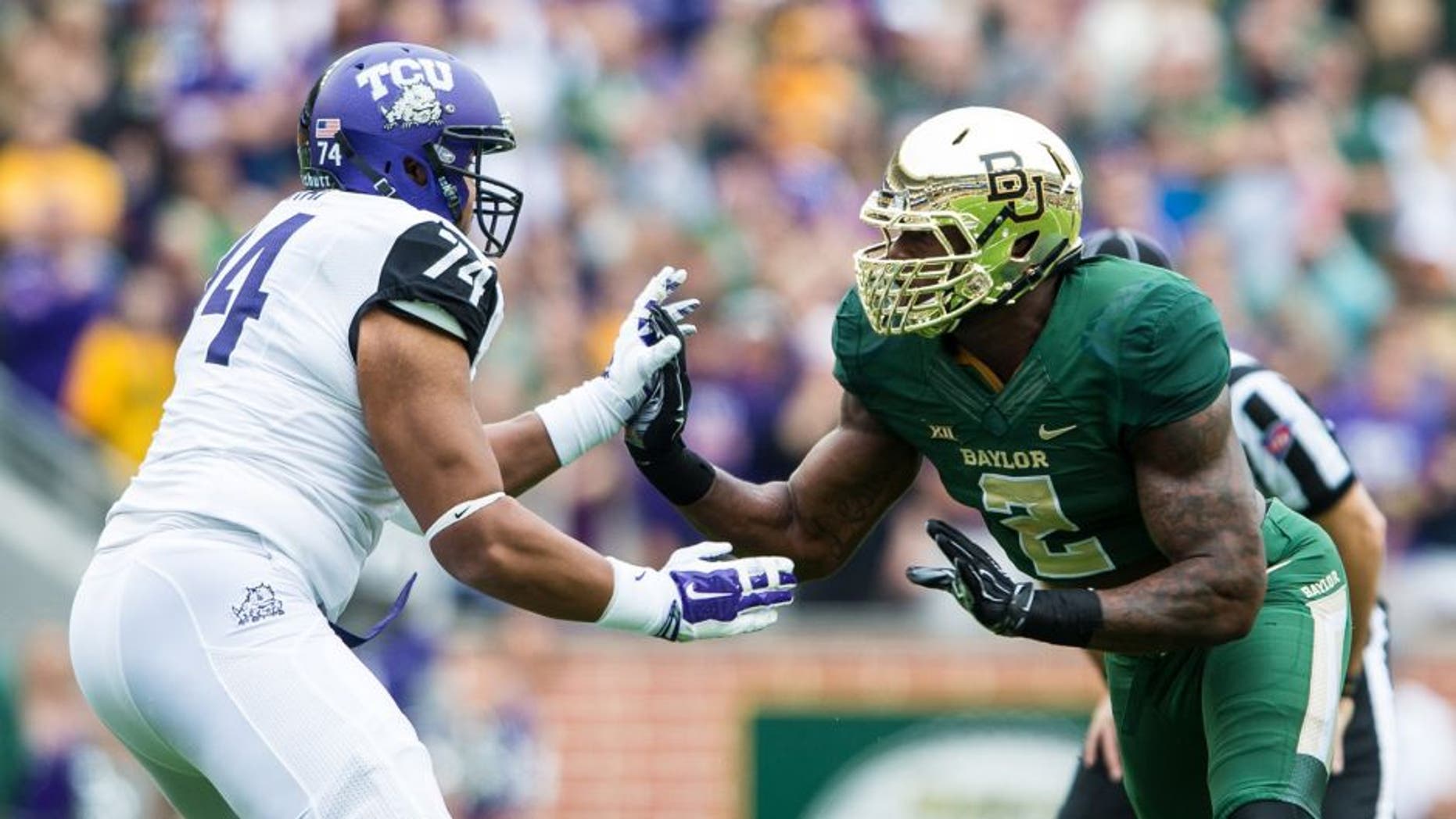 Oct 11, 2014; Waco, TX, USA; TCU Horned Frogs offensive tackle Halapoulivaati Vaitai (74) faces off against Baylor Bears defensive end Shawn Oakman (2) during the game at McLane Stadium. The Bears defeat Horned Frogs 61-58. Mandatory Credit: Jerome Miron-USA TODAY Sports