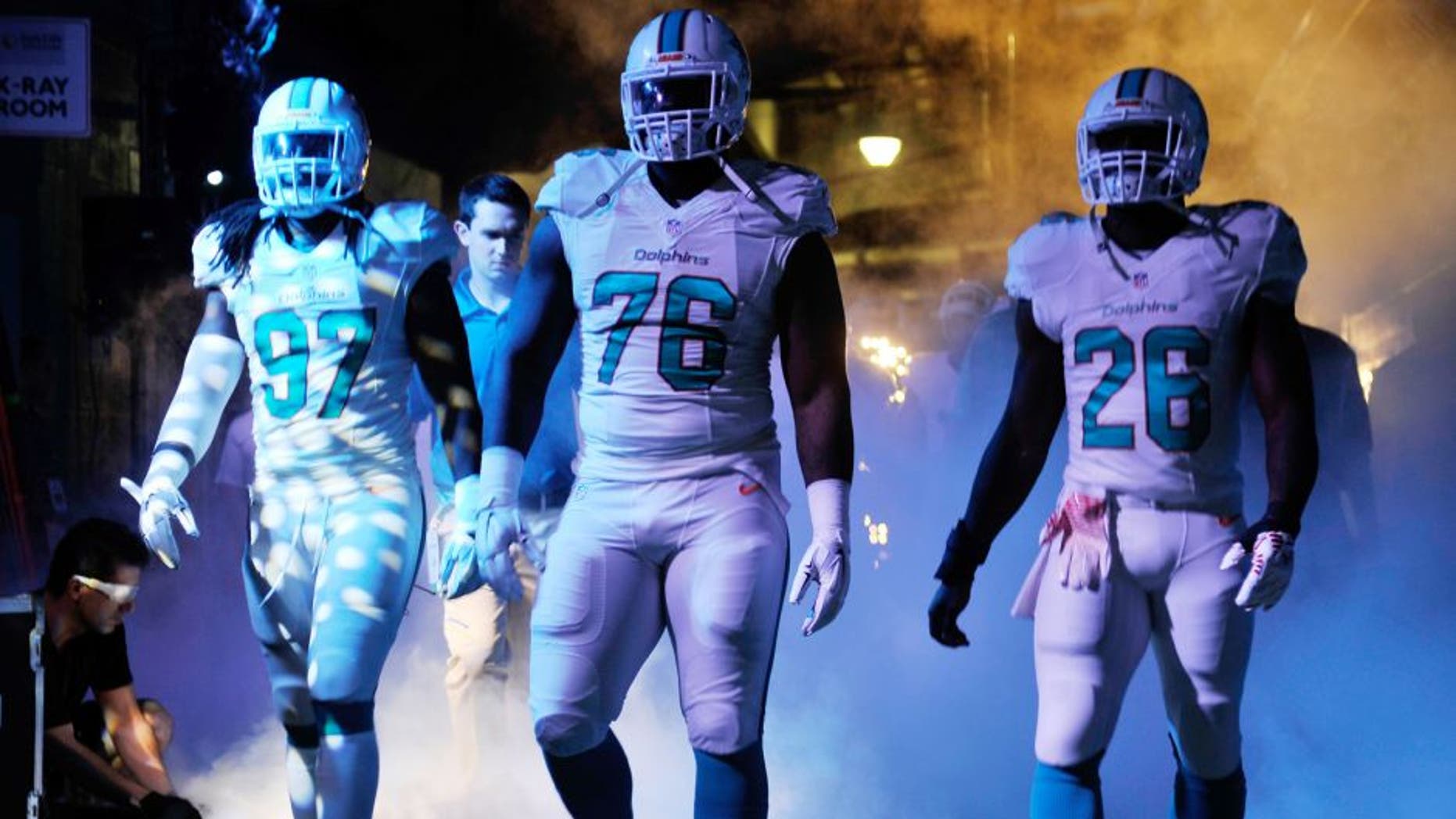 Dec 7, 2014; Miami Gardens, FL, USA; Miami Dolphins linebacker Kelvin Sheppard (left), defensive end Terrence Fede (center) and running back Knowshon Moreno (right) prepare to take the field before a game against the Baltimore Ravens at Sun Life Stadium. Mandatory Credit: Steve Mitchell-USA TODAY Sports