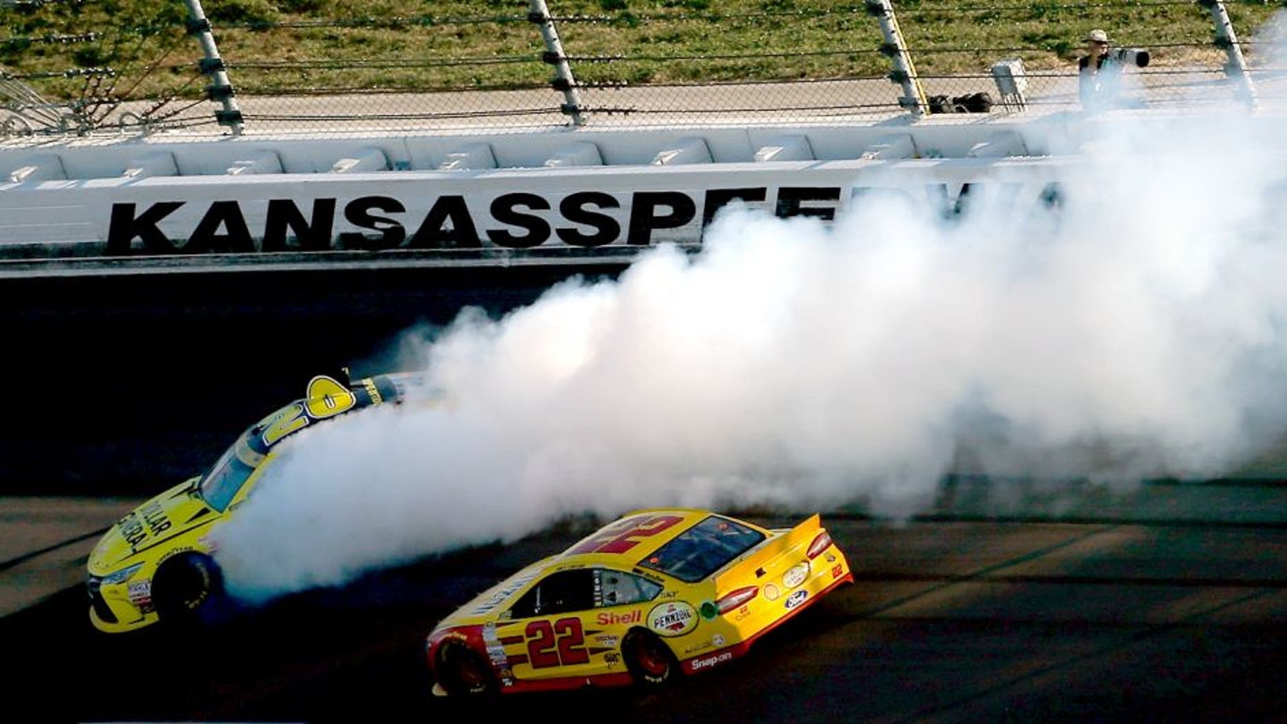 KANSAS CITY, KS - OCTOBER 18: Matt Kenseth, driver of the #20 Dollar General Toyota, spins as Joey Logano, driver of the #22 Shell Pennzoil Ford, races by during the NASCAR Sprint Cup Series Hollywood Casino 400 at Kansas Speedway on October 18, 2015 in Kansas City, Kansas. (Photo by Todd Warshaw/Getty Images)