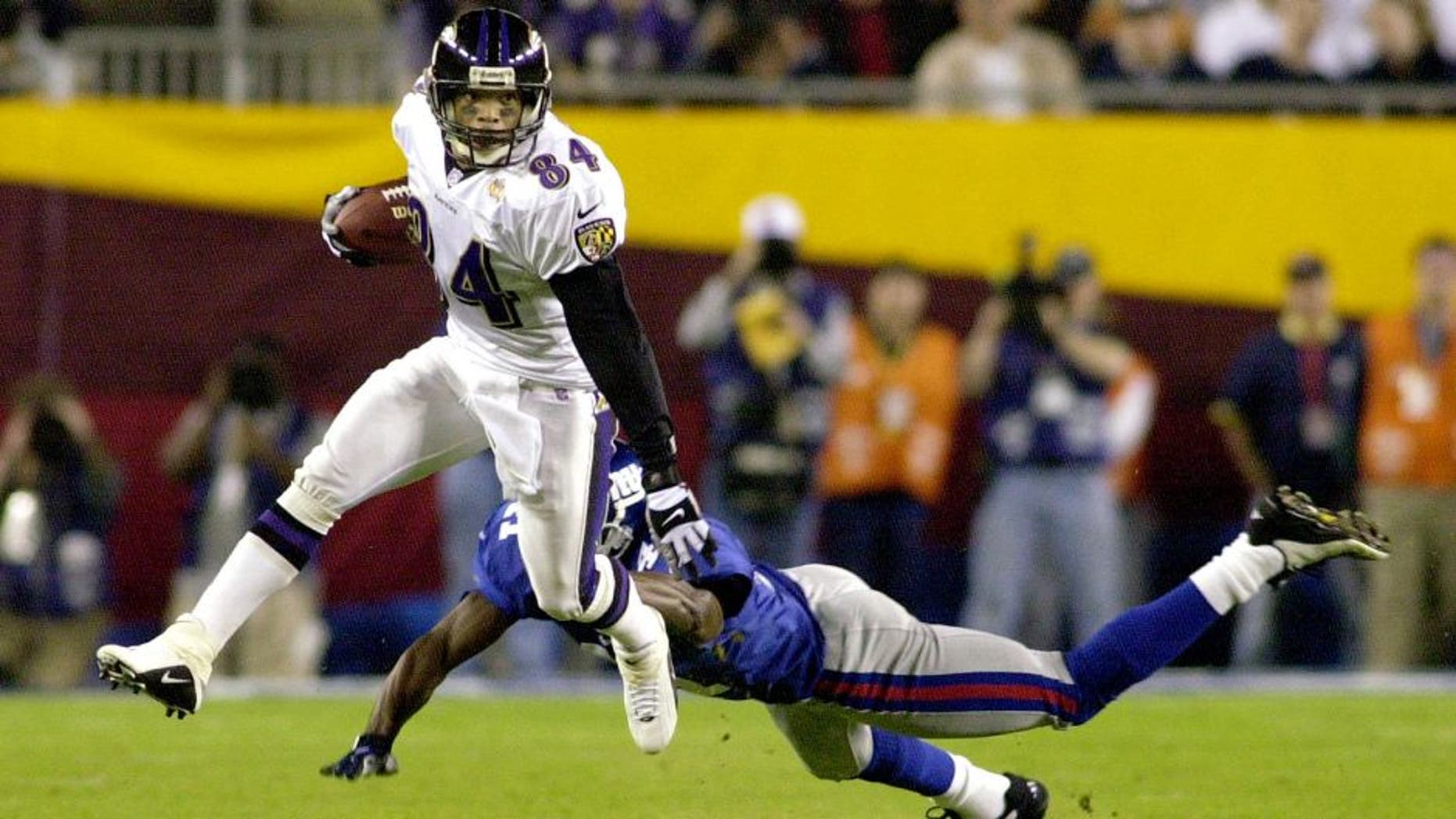 TAMPA, FL - JANUARY 28: Baltimore Ravens' wide receiver Jermaine Lewis (L) avoids an open field tackle by Dave Thomas of the New York Giant defender during first half action in Super Bowl XXXV 28 January, 2001, at Raymond James Stadium in Tampa, Florida. The New York Giants and the Baltimore Ravens are playing for the Vince Lombardi Trophy and the NFL championship. (Photo credit should read PETER MUHLY/AFP/Getty Images)