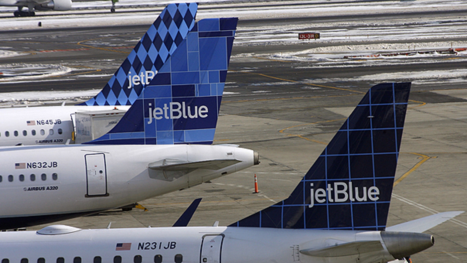 In this Feb. 20, 2007 file photo, JetBlue airplanes display their registration numbers along the windows at the rear of the aircraft at John F. Kennedy International Airport in New York.