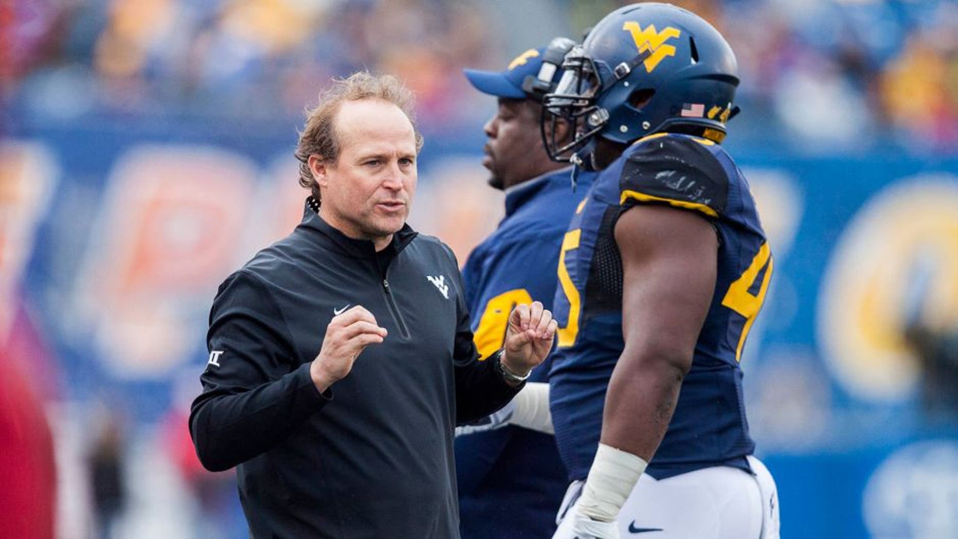 Nov 28, 2015; Morgantown, WV, USA; West Virginia Mountaineers head coach Dana Holgorsen talks with players on the sideline during the second quarter against the Iowa State Cyclones at Milan Puskar Stadium. Mandatory Credit: Ben Queen-USA TODAY Sports
