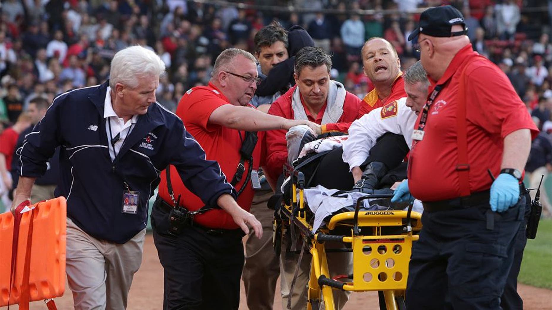 BOSTON - JUNE 5: Medical personnel remove a fan injured by a broken bat in the second inning. The Boston Red Sox take on the Oakland Athletics in Game 1 of a three game series at Fenway Park. (Photo by Barry Chin/The Boston Globe via Getty Images)