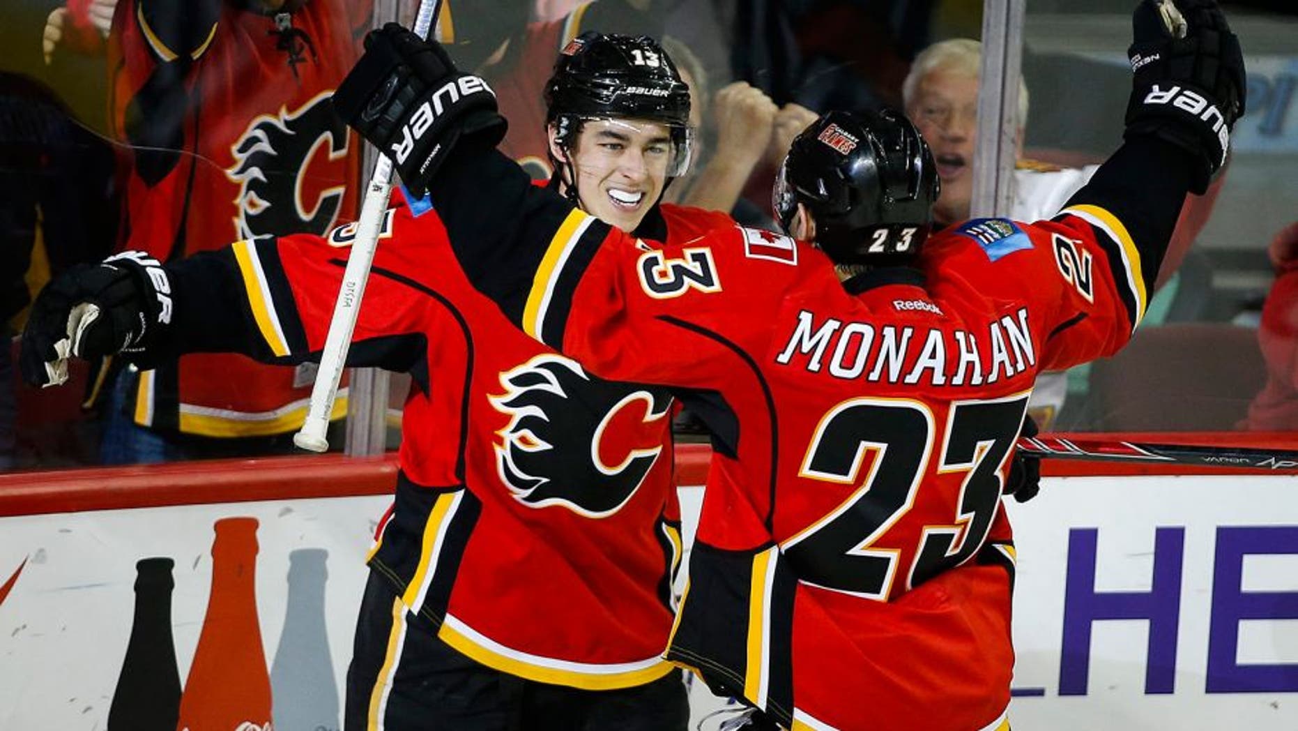 Calgary Flames' Johnny Gaudreau, left, celebrates his game-winning goal with teammate Sean Monahan during third period NHL hockey action against the Buffalo Sabres, in Calgary, on Thursday, Dec. 10, 2015. (Jeff McIntosh/The Canadian Press via AP) MANDATORY CREDIT