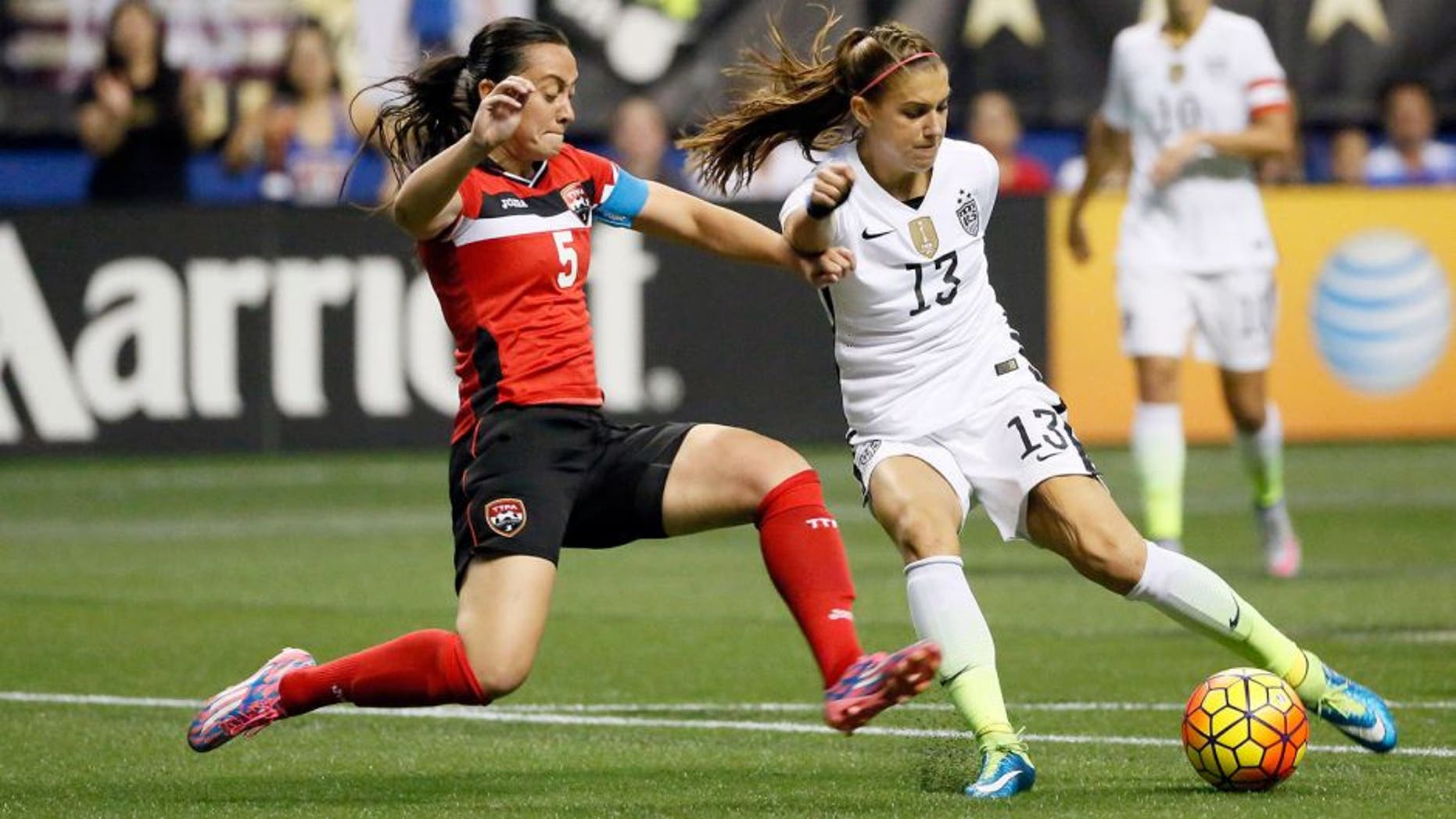 Dec 10, 2015; San Antonio, TX, USA; United States forward Alex Morgan (13) is defended by Trinidad & Tobago defender Arin King (5) during the first half at Alamodome. Mandatory Credit: Soobum Im-USA TODAY Sports