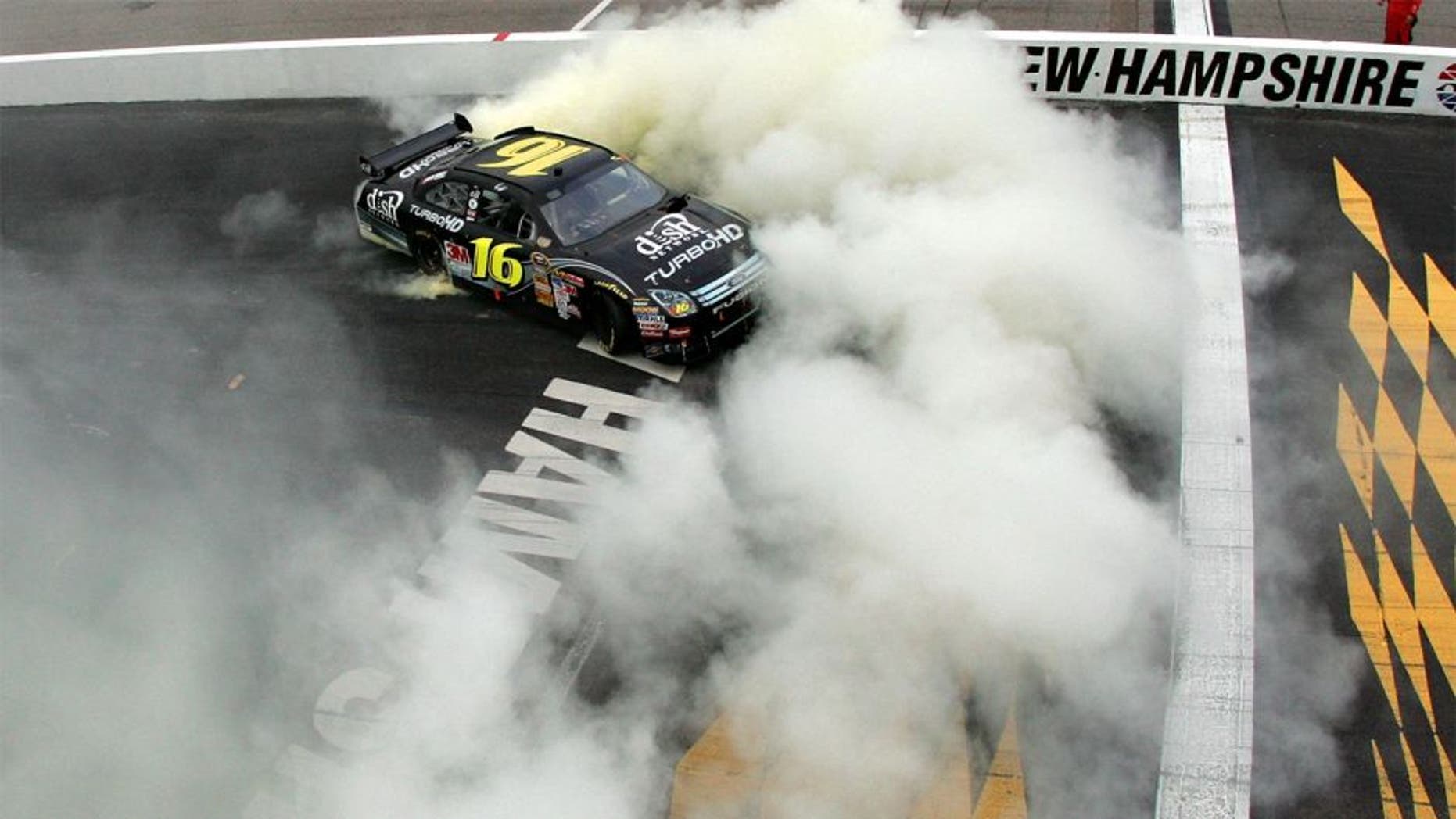 LOUDON, NH - SEPTEMBER 14: Greg Biffle, driver of the #16 Dish Network Turbo HD Ford, does a burnout following his victory in the NASCAR Sprint Cup Series Sylvania 300 at New Hampshire Motor Speedway on September 14, 2008 in Loudon, New Hampshire. (Photo by Chris Trotman/Getty Images for NASCAR)