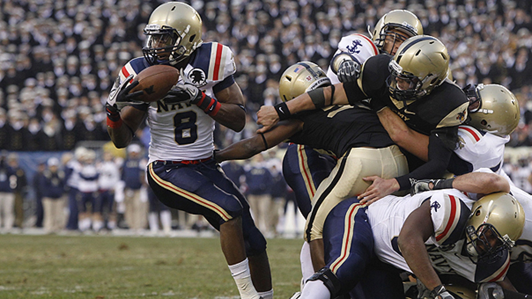 Dec. 11: Navy safety Wyatt Middleton, left, grabs a loose ball from Army quarterback Trent Steelman, right, in the first half of an NCAA college football game, in Philadelphia.