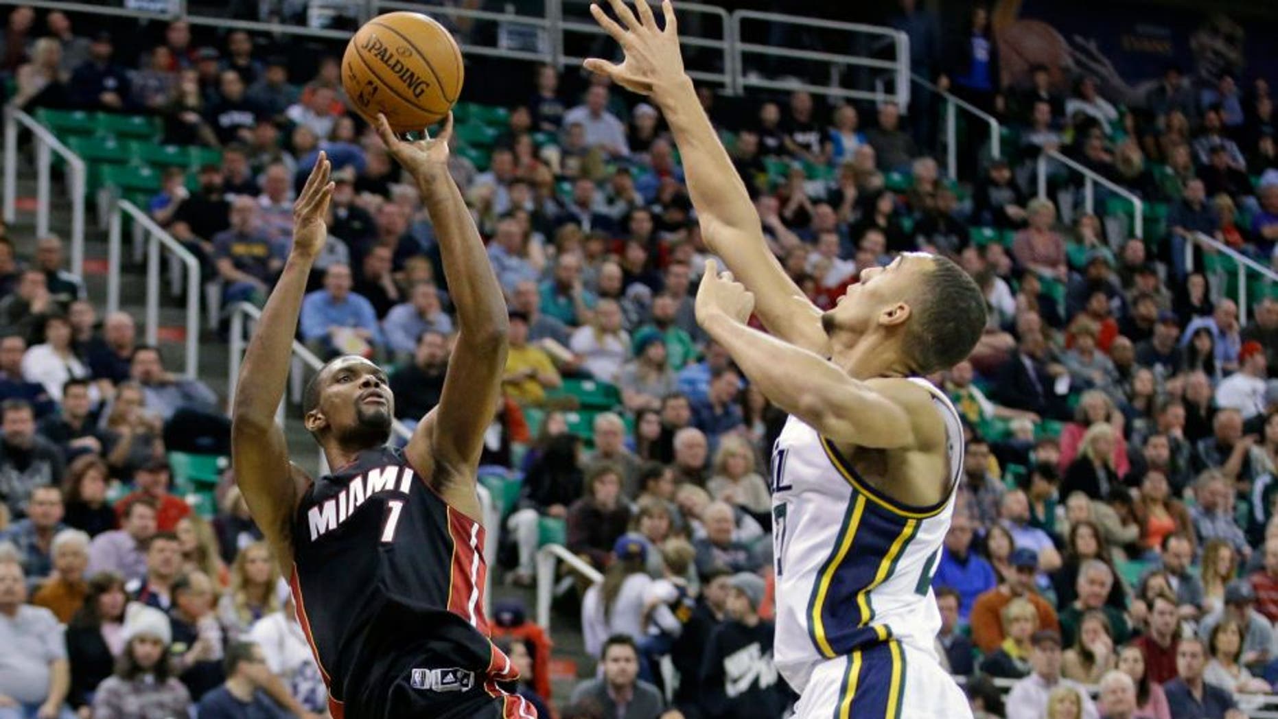 Miami Heat center Chris Bosh (1) shoots as Utah Jazz center Rudy Gobert, right, defends in the second quarter during an NBA basketball game Friday, Dec. 12, 2014, in Salt Lake City. (AP Photo/Rick Bowmer)