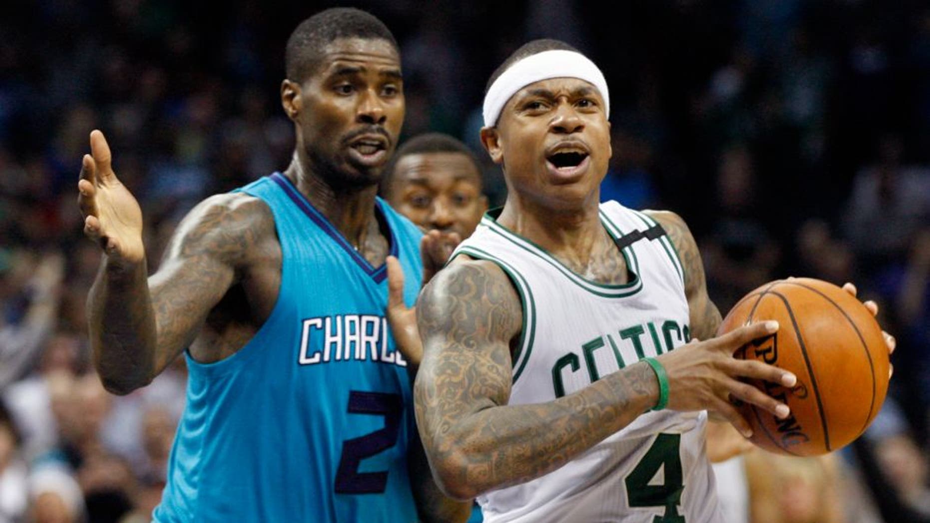 Boston Celtics guard Isaiah Thomas, right, protects the ball from Charlotte Hornets forward Marvin Williams in the second of an NBA basketball game Saturday, Dec. 12, 2015 in Charlotte, N.C. Boston won 98-93. (AP Photo/Nell Redmond)