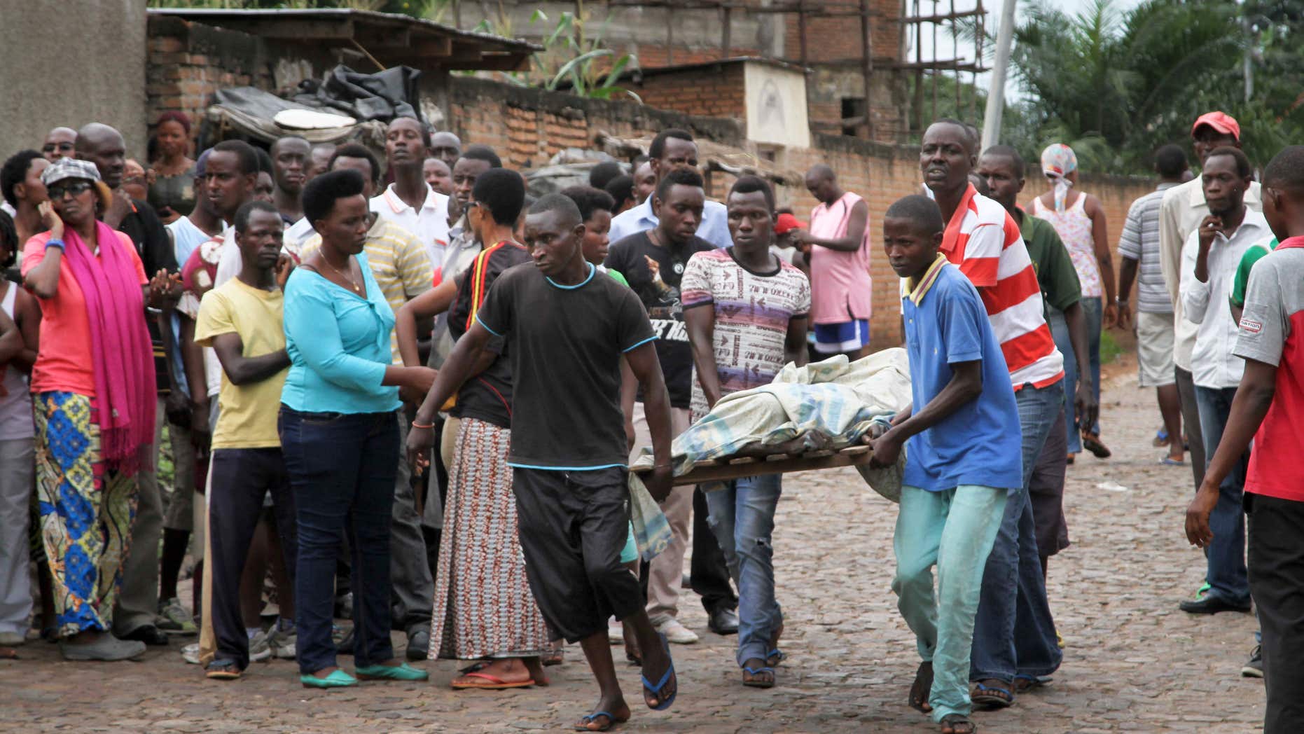 Dec. 12, 2015: Men carry away a dead body in the Nyakabiga neighborhood of Bujumbura, Burundi.