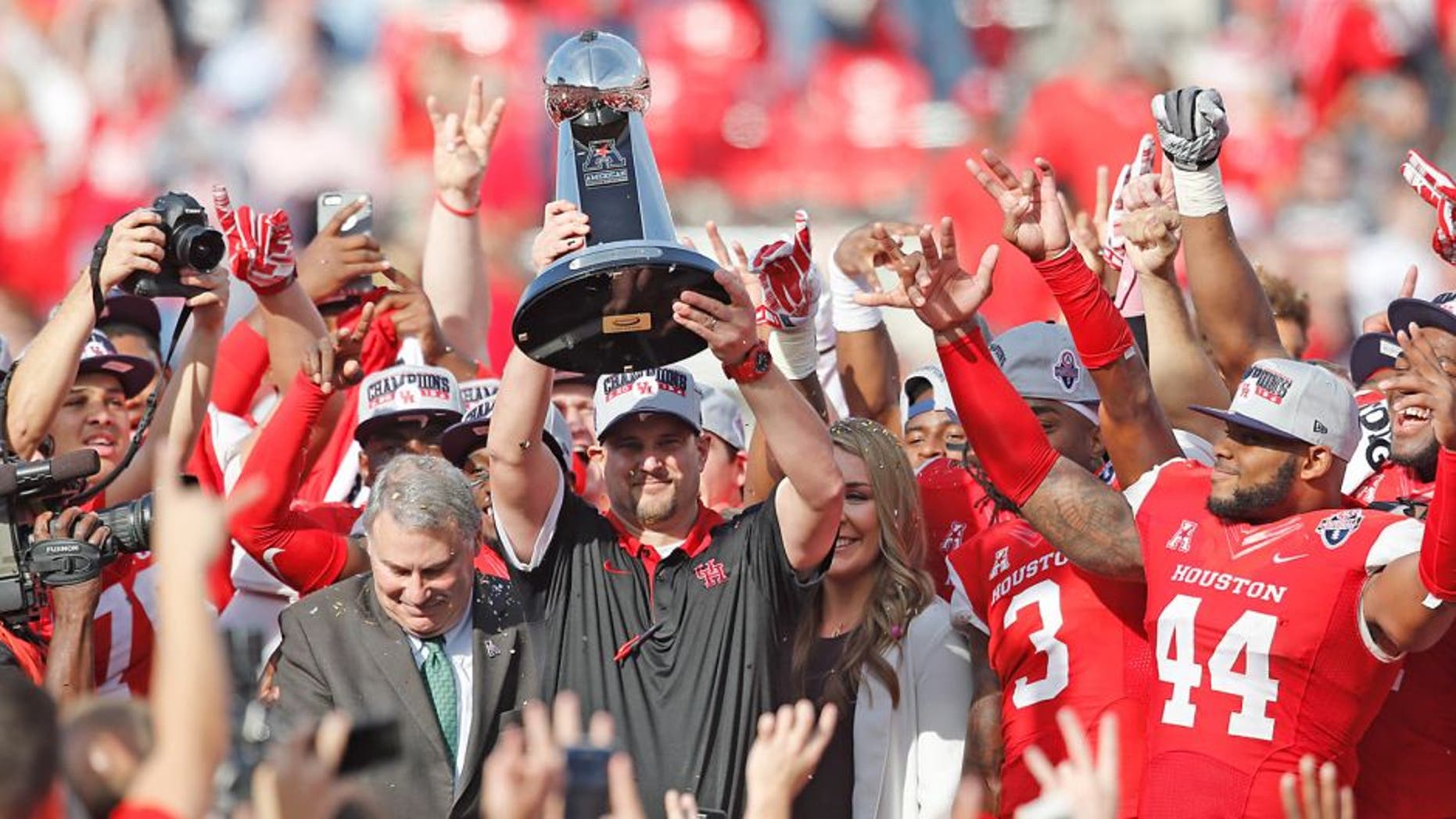 Dec 5, 2015; Houston, TX, USA; Houston Cougars head coach Tom Herman hold up the 2015 Mid-American Conference trophy after defeating the Temple Owls in the in the Mid-American Conference football championship game at TDECU Stadium. Houston won 24 to 13. Mandatory Credit: Thomas B. Shea-USA TODAY Sports