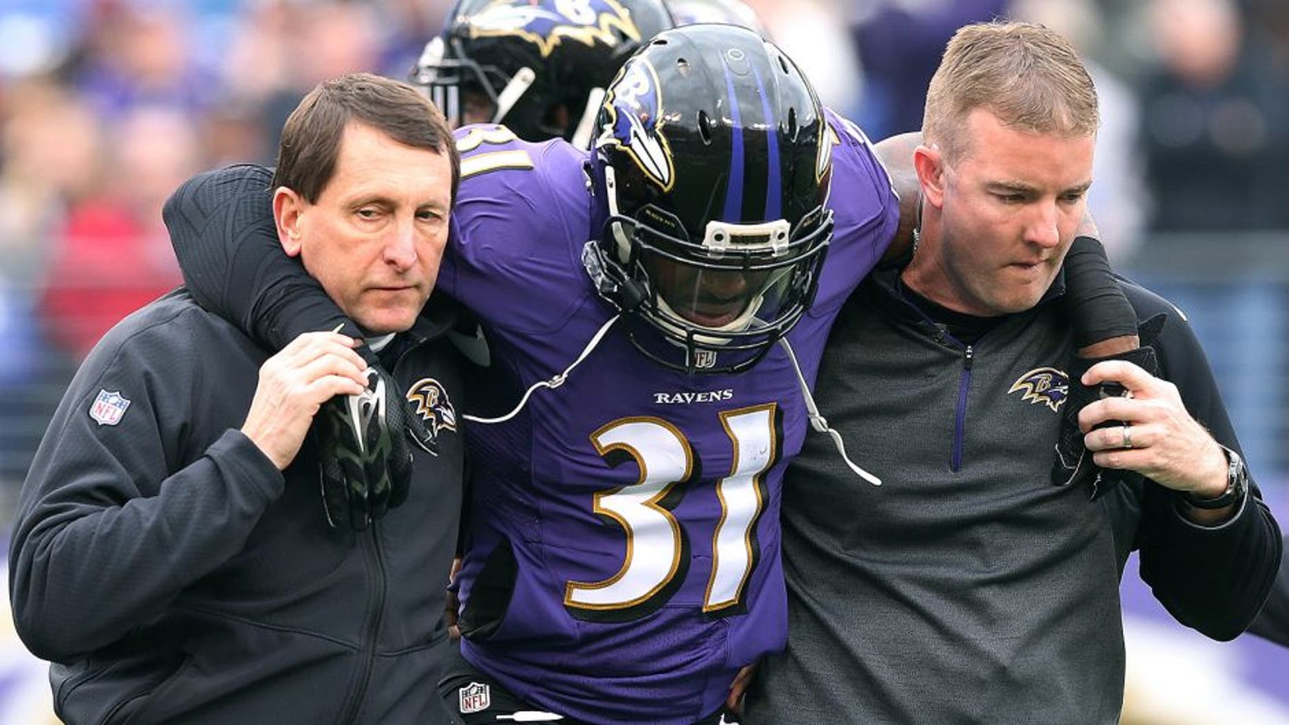Dec 14, 2014; Baltimore, MD, USA; Baltimore Ravens safety Terrence Brooks (31) is assisted off the field after suffering an apparent injury on the opening kickoff against the Jacksonville Jaguars at M&T Bank Stadium. Mandatory Credit: Mitch Stringer-USA TODAY Sports