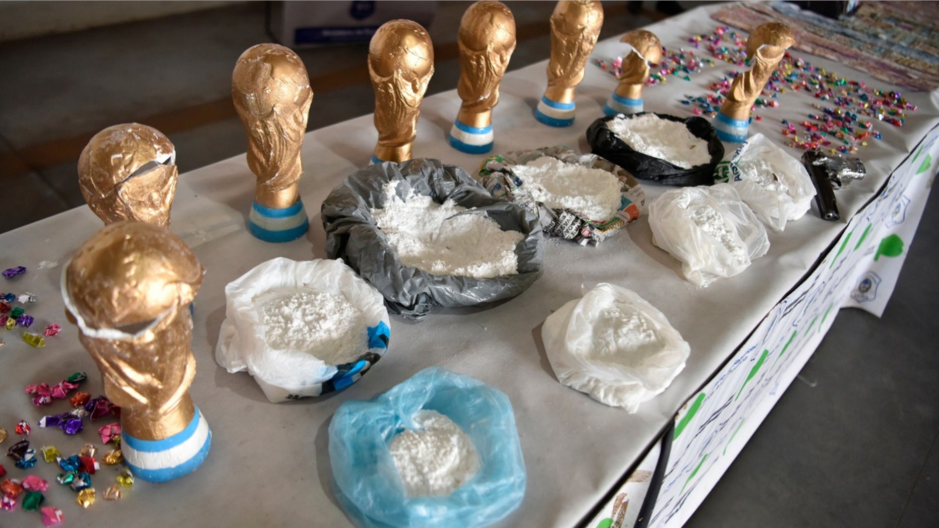 This Thursday, June 21 photo, released by the National Security Ministry shows fake World Cup trophies stuffed with cocaine, and the product itself on display next to the trophies, in Buenos Aires, Argentina.