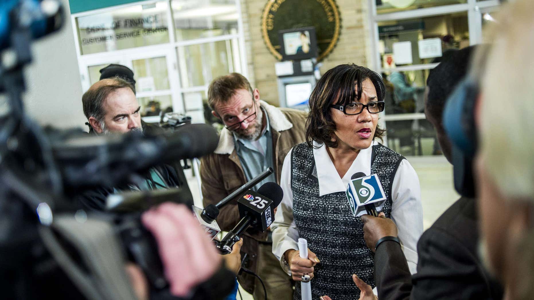 Dec. 15, 2015: A swarm of reporters surround Flint Mayor Karen Weaver to ask question after a news conference at City Hall in Flint, Mich.