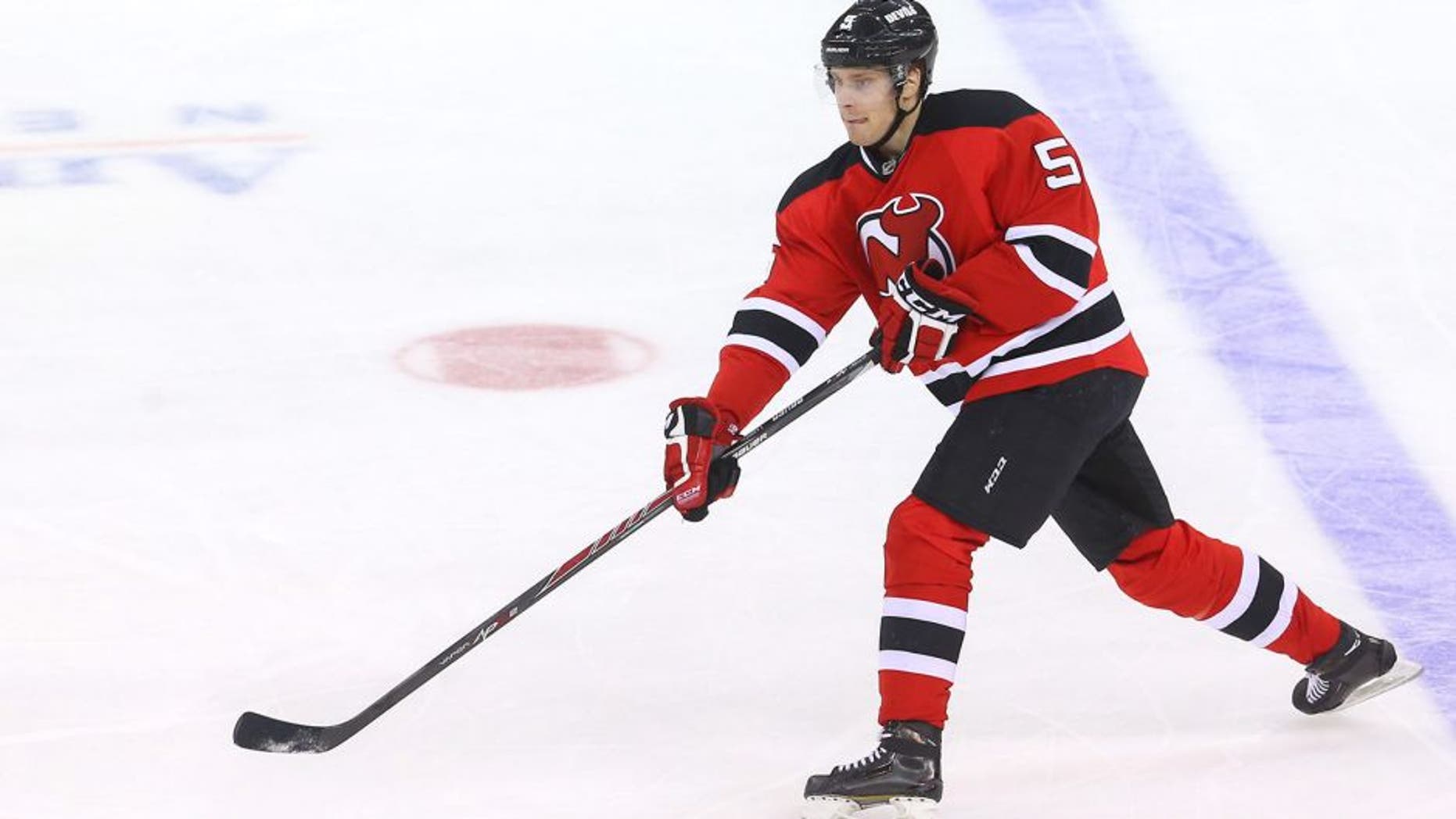 Mar 31, 2014; Newark, NJ, USA; New Jersey Devils defenseman Adam Larsson (5) passes the puck against the Florida Panters during the third period at Prudential Center. The Devils won 6-3. Mandatory Credit: Ed Mulholland-USA TODAY Sports
