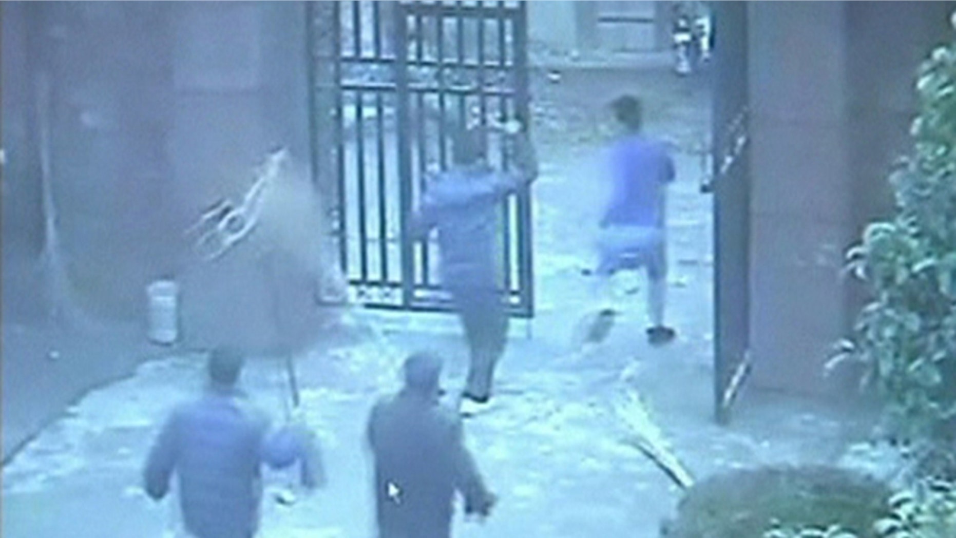 People chase a man (R), who attacked students with a knife, out of an elementary school in Guangshan county, Henan province, in this still image from a December 14, 2012 surveillance video, released by local police December 18, 2012.