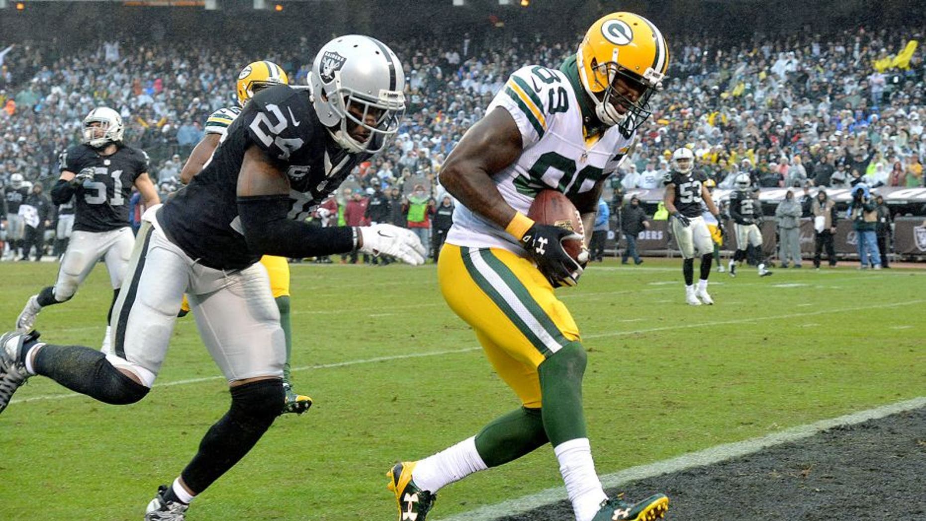 Dec 20, 2015; Oakland, CA, USA; Green Bay Packers wide receiver James Jones (89) is defended by Oakland Raiders free safety Charles Woodson (24) on a 30-yard touchdown reception in the third quarter during an NFL football game at O.co Coliseum. The Packers defeated the Raiders 30-20. Mandatory Credit: Kirby Lee-USA TODAY Sports