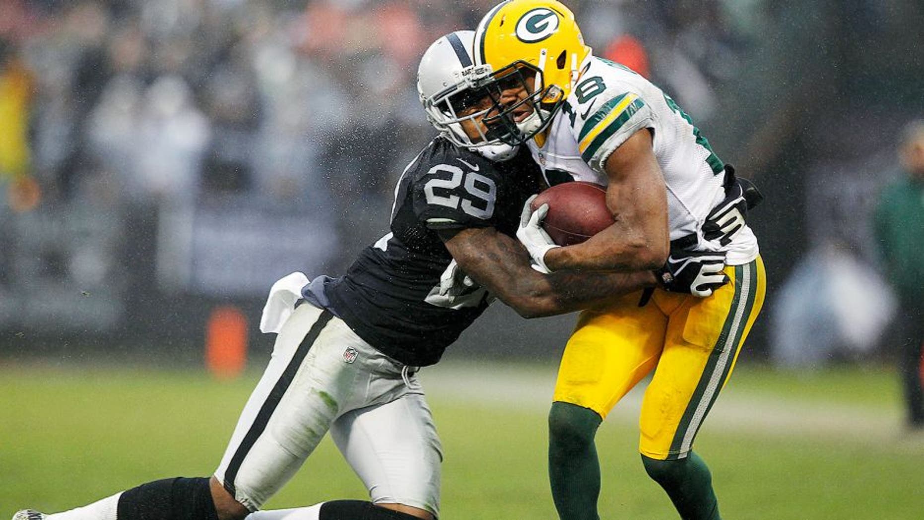 Dec 20, 2015; Oakland, CA, USA; Green Bay Packers wide receiver Randall Cobb (18) is hit by Oakland Raiders cornerback David Amerson (29) in the fourth quarter at O.co Coliseum. The Packers defeated the Raiders 30-20. Mandatory Credit: Cary Edmondson-USA TODAY Sports
