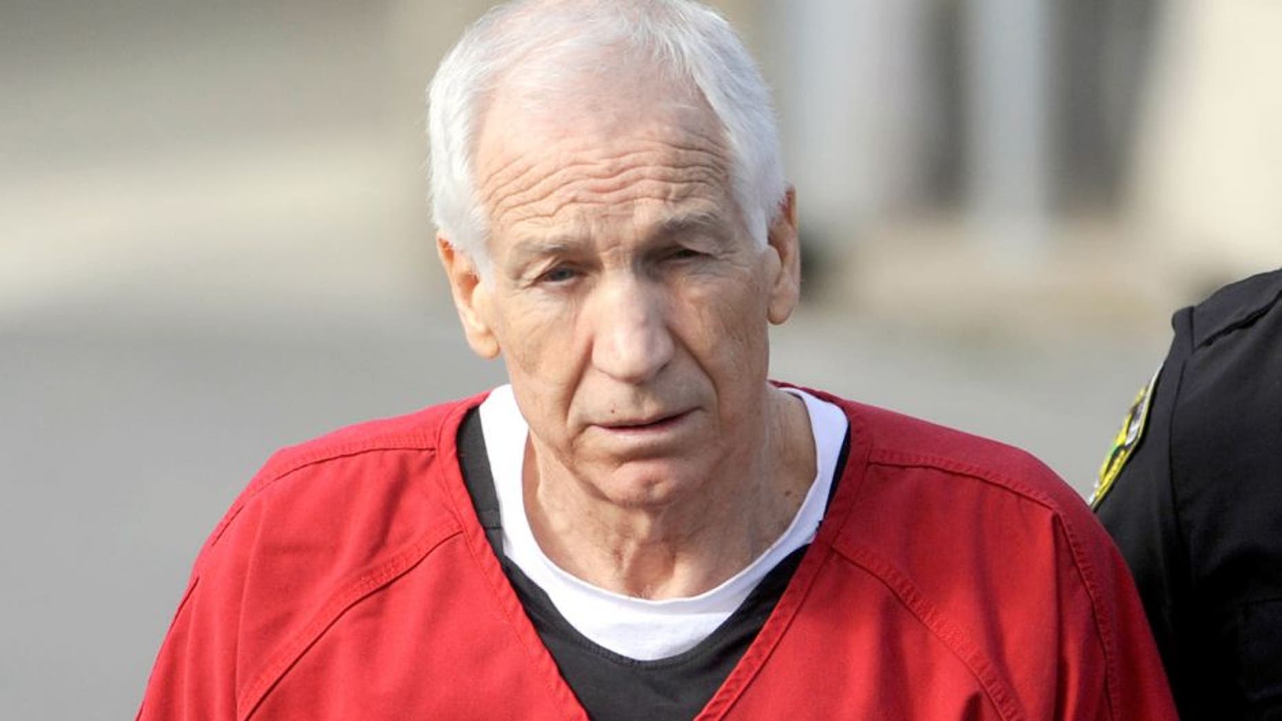 Jerry Sandusky, center, is escorted from his sentencing at the Centre County Courthouse in Bellefonte on Tuesday, October 9, 2012. Sandusky, maintaining his innocence, was sentenced Tuesday to at least 30 years in prison, effectively a life sentence, in the child sexual abuse scandal that brought shame to Penn State and led to coach Joe Paterno's downfall. (Christopher Weddle/Centre Daily Times/MCT)