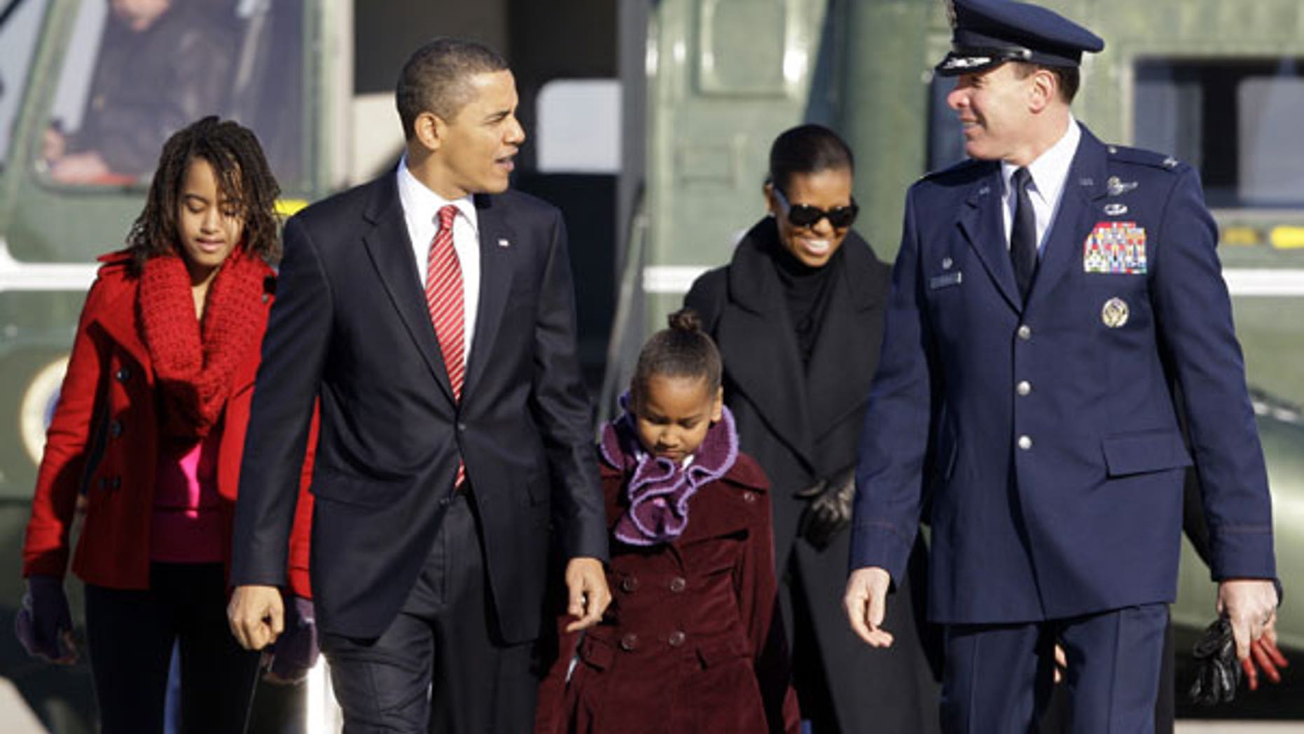 Thursday: President Barack Obama, walks with Malia Obama, 11, left, Sasha Obama 8, and Michelle Obama, with Col. Steven Shepro, to Air Force One at Andrews Air Force Base, Md., on their way to Hawaii for Christmas. (AP Photo)