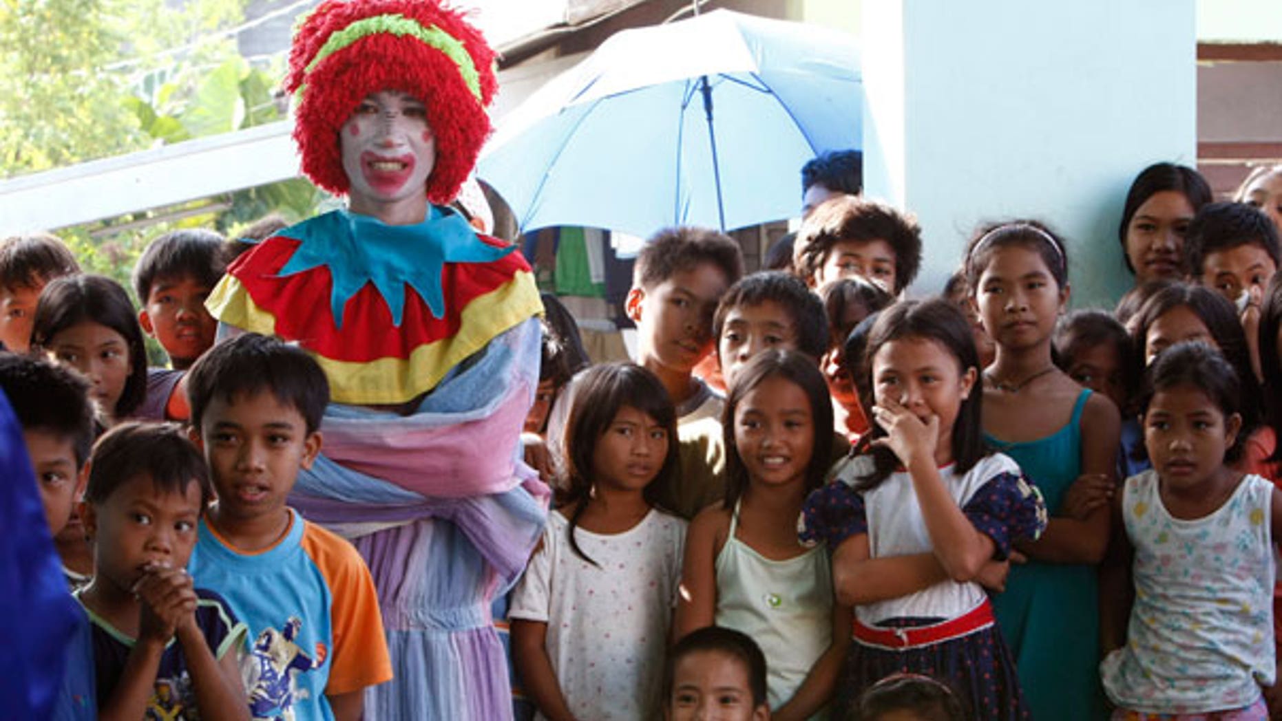 Dec. 25: An entertainer dressed as a clown watches another performance together with Mayon volcano children evacuees during a Christmas celebration at an evacuation center in Legazpi City, Philippines.