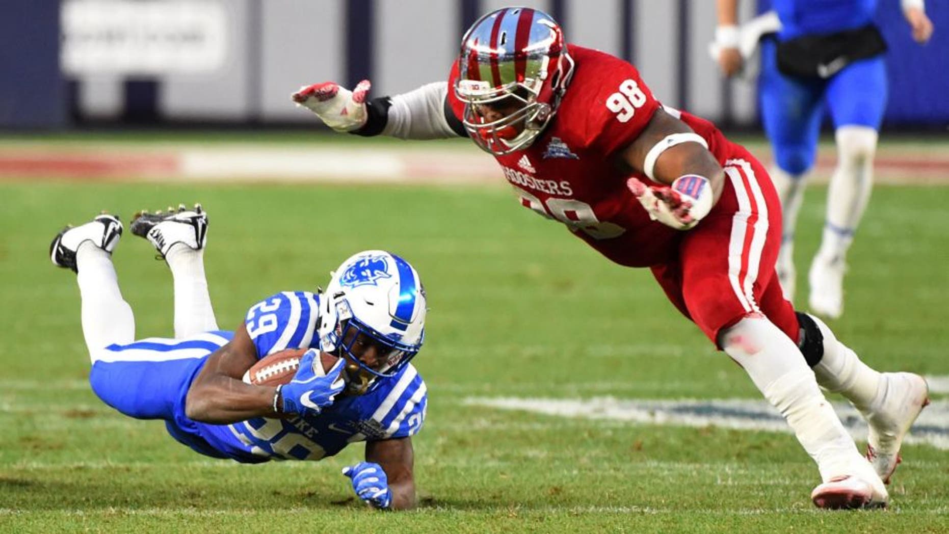 Dec 26, 2015; Bronx, NY, USA; Duke Blue Devils running back Shaun Wilson (29) dives for extra yards as Indiana Hoosiers defensive lineman Darius Latham (98) defends during the first quarter in the 2015 New Era Pinstripe Bowl at Yankee Stadium. Mandatory Credit: Rich Barnes-USA TODAY Sports