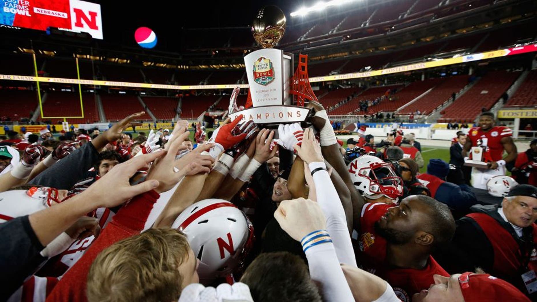 SANTA CLARA, CA - DECEMBER 26: The Nebraska Cornhuskers celebrate with the trophy after they beat the UCLA Bruins in the Foster Farms Bowl at Levi's Stadium on December 26, 2015 in Santa Clara, California. (Photo by Ezra Shaw/Getty Images)