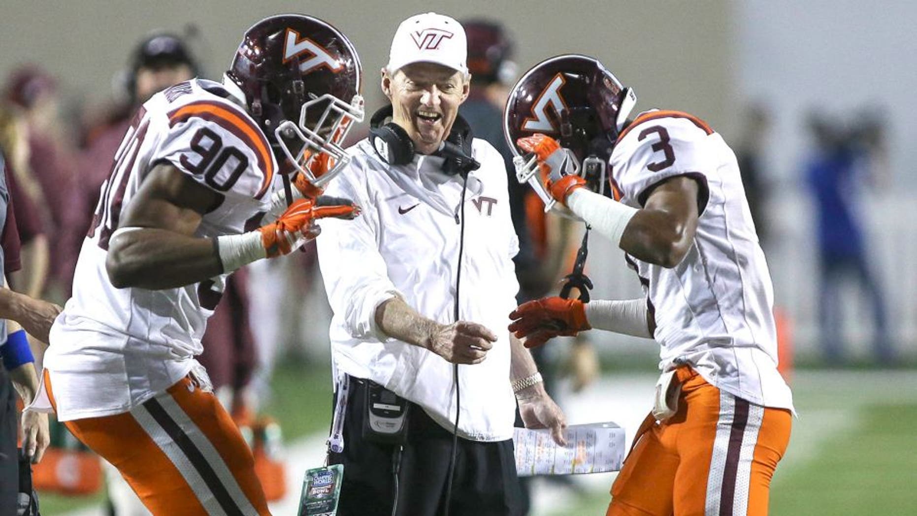 Dec 26, 2015; Shreveport, LA, USA; Virginia Tech Hokies head coach Frank Beamer celebrates with defensive end Dadi Lhomme Nicolas (90) and cornerback Greg Stroman (3) after Stroman returns a punt for a touchdown during the second quarter against the Tulsa Golden Hurricane at Independence Stadium. Mandatory Credit: Troy Taormina-USA TODAY Sports