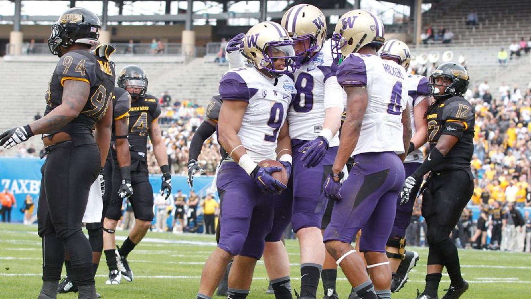 Dec 26, 2015; Dallas, TX, USA; Washington Huskies fullback Myles Gaskin (9) is congratulated after scoring a touchdown by tight end Drew Sample (88) and wide receiver Jaydon Mickens (4) in the first quarter against the Southern Miss Golden Eagles at Cotton Bowl Stadium. Mandatory Credit: Tim Heitman-USA TODAY Sports