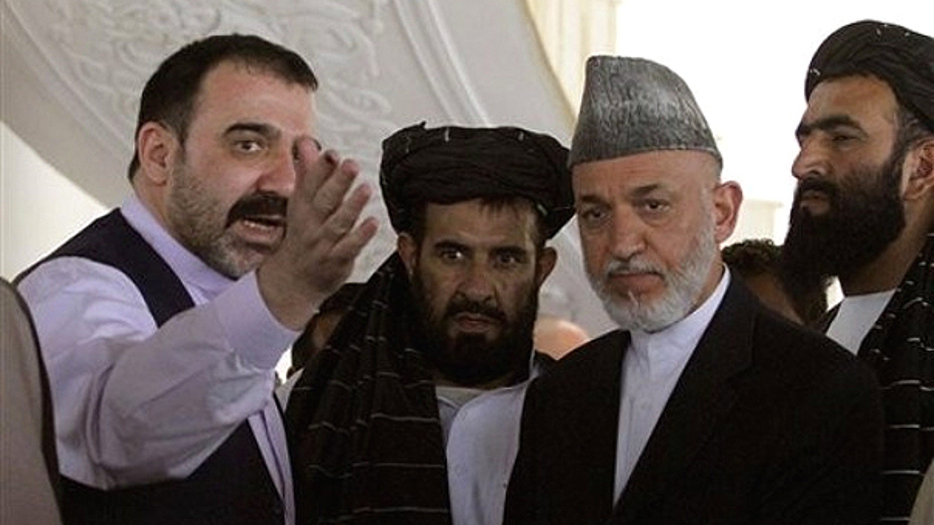 Oct. 9, 2010: Afghan President Hamid Karzai, second from right, is met by his half brother Ahmad Wali Karzai, left, in Argandab district of Kandahar province, south of Kabul, Afghanistan.