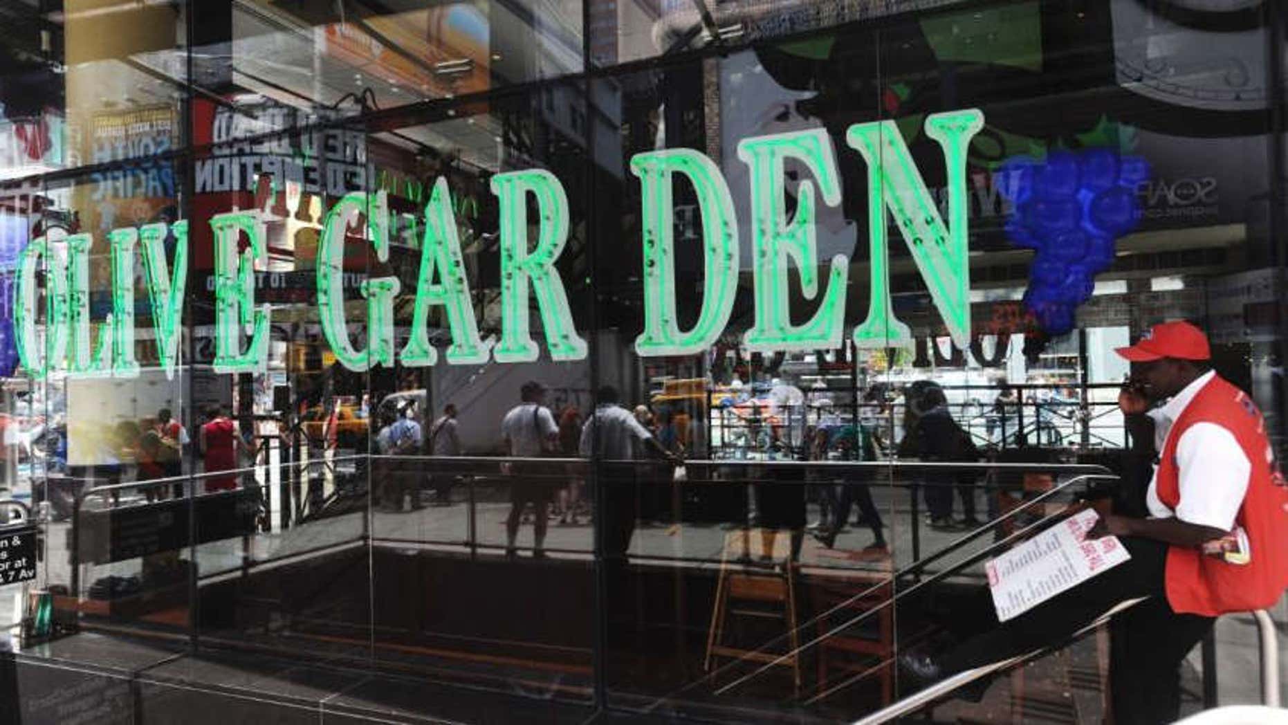 A man talks on his mobile phone in front of the Times Square Olive Garden in New York.