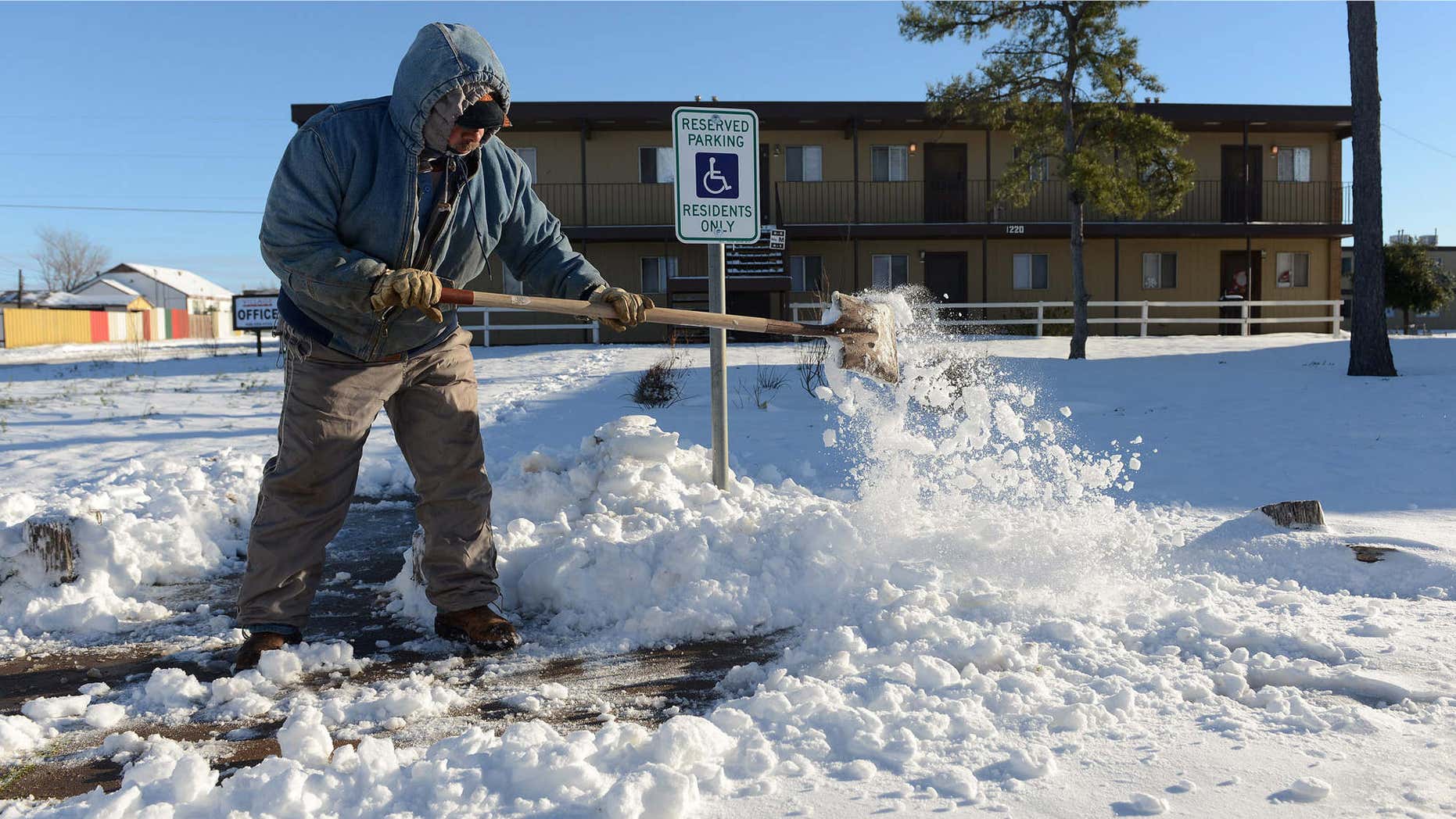 Dec. 28, 2015: Ismael Avelar, maintenance employee for the Village Place Apartments, shovels snow Monday morning from the walkway to the apartment complex office in Odessa, Texas.