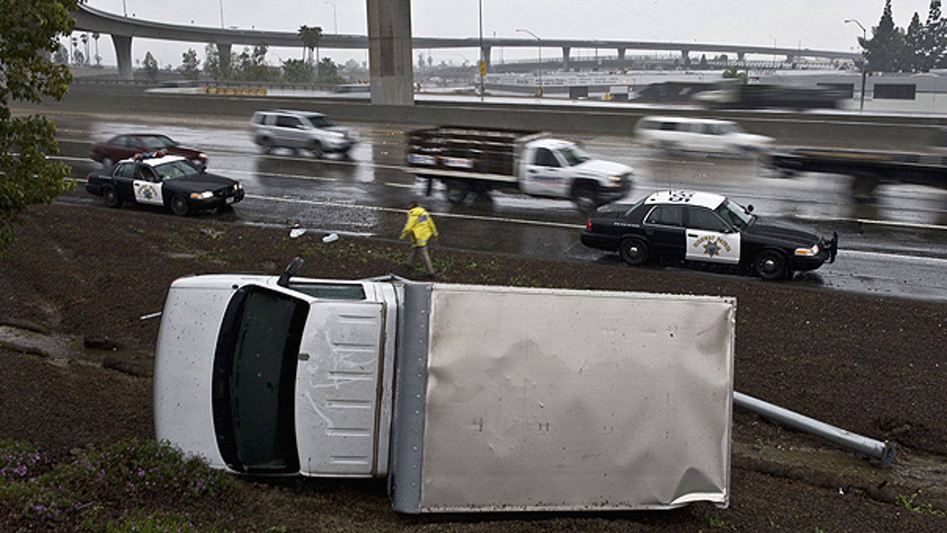 Dec. 29: A truck lands on its side after the driver lost control while driving too fast in the rain, and flipped over on the right shoulder of the northbound 57 in Anaheim, Calif.