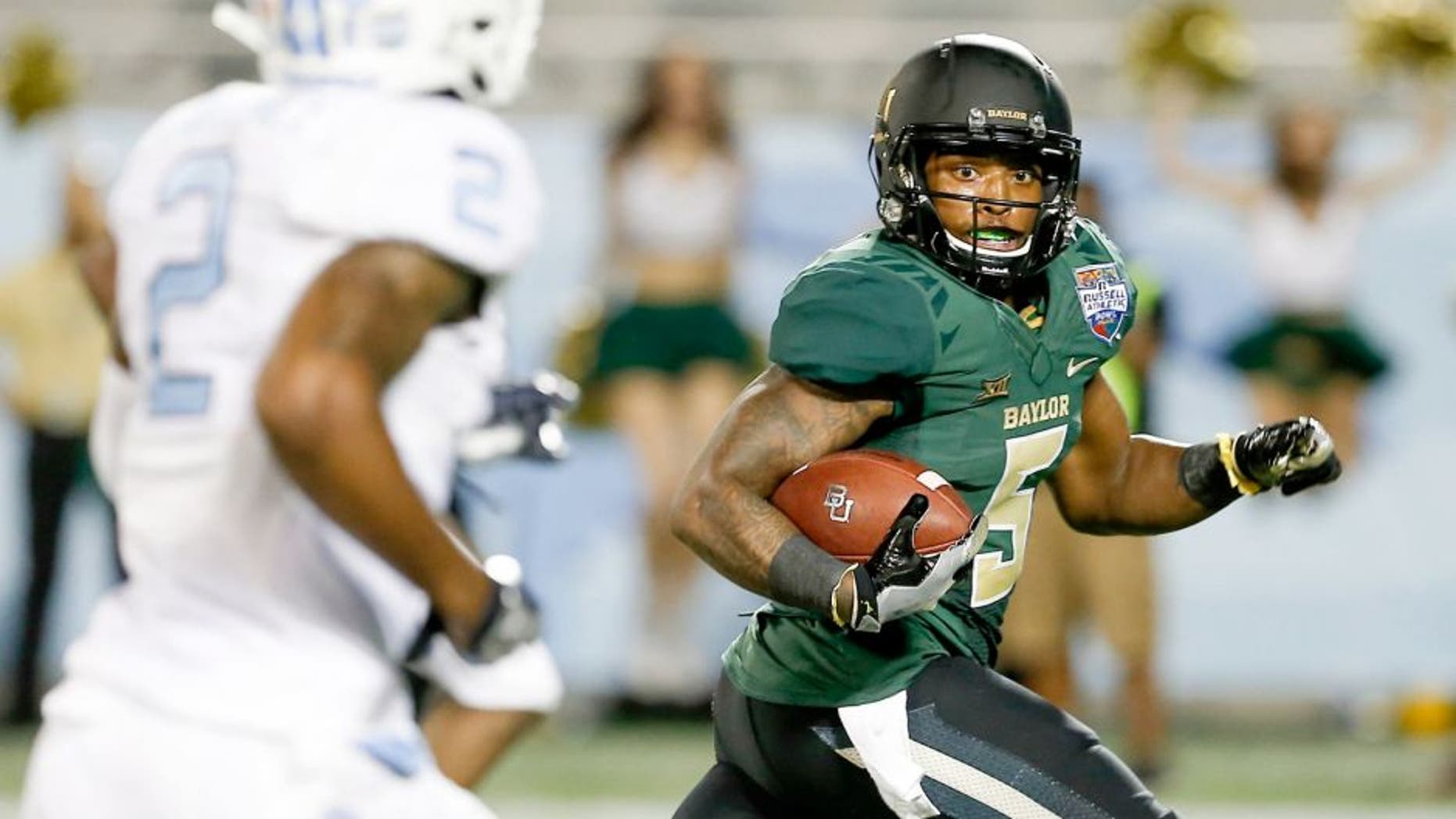Dec 29, 2015; Orlando, FL, USA; Baylor Bears running back Johnny Jefferson (5) looks back at North Carolina Tar Heels cornerback Des Lawrence (2) before scoring on a touchdown run during the second quarter of a football game at Florida Citrus Bowl. Mandatory Credit: Reinhold Matay-USA TODAY Sports