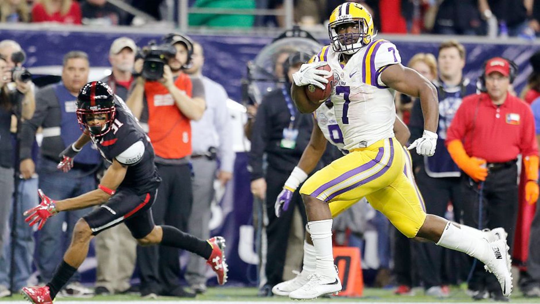 Dec 29, 2015; Houston, TX, USA; LSU Tigers running back Leonard Fournette (7) catches the ball and runs for a touchdown against the Texas Tech Red Raiders in the second quarter at NRG Stadium. Mandatory Credit: Thomas B. Shea-USA TODAY Sports